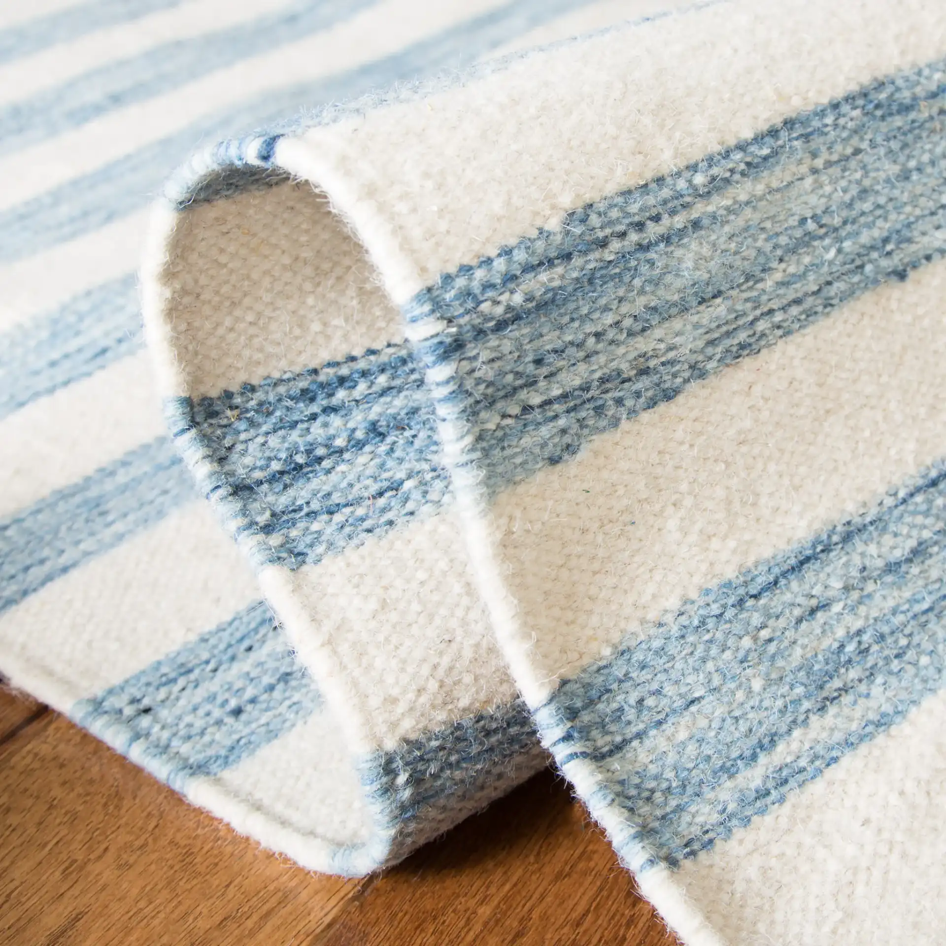 Dhurries Striped Hand-Woven Wool Rug in Blue / Ivory in a styled room