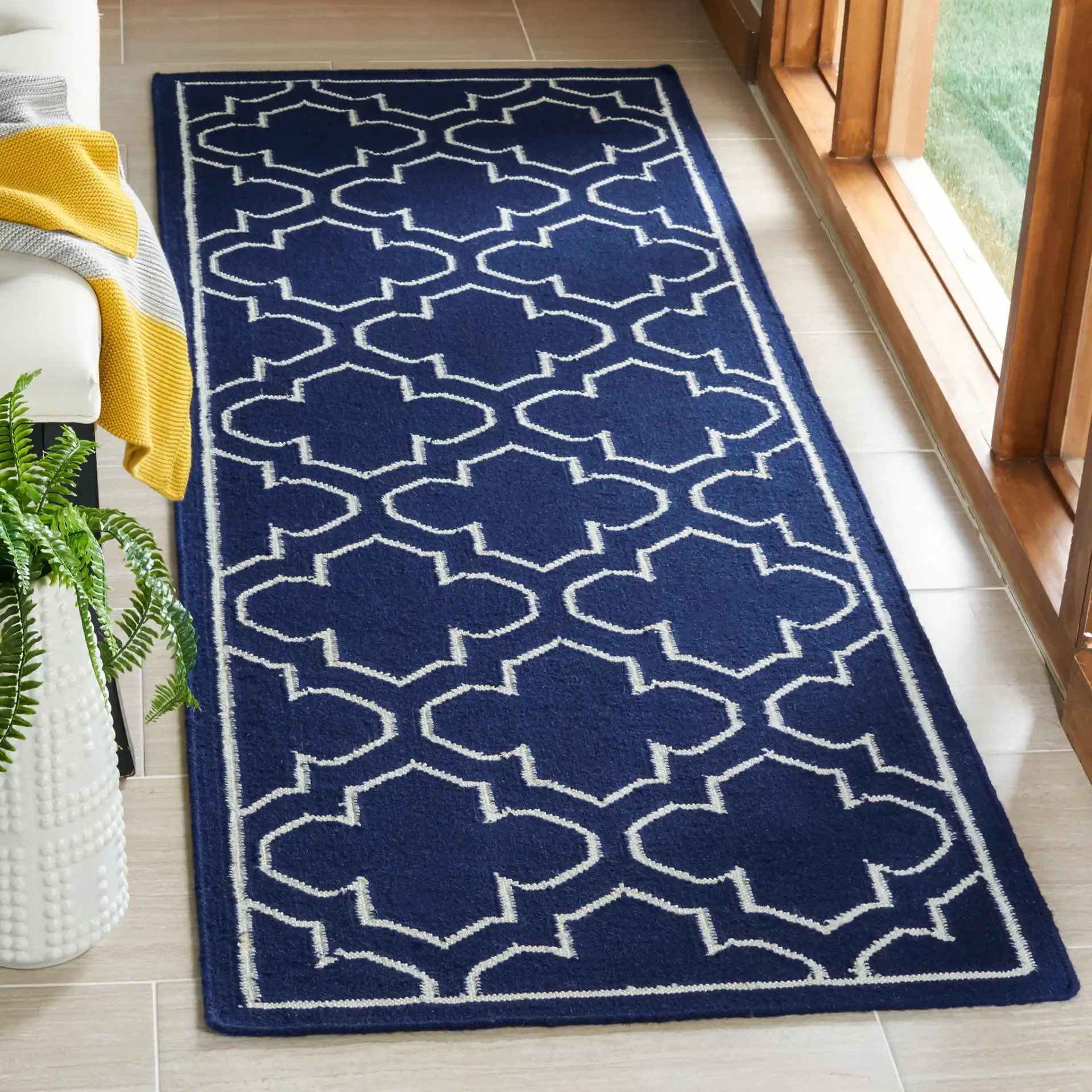 Dhurries Bordered Quatrefoil Hand-Woven Rug in Navy / Ivory in a styled room