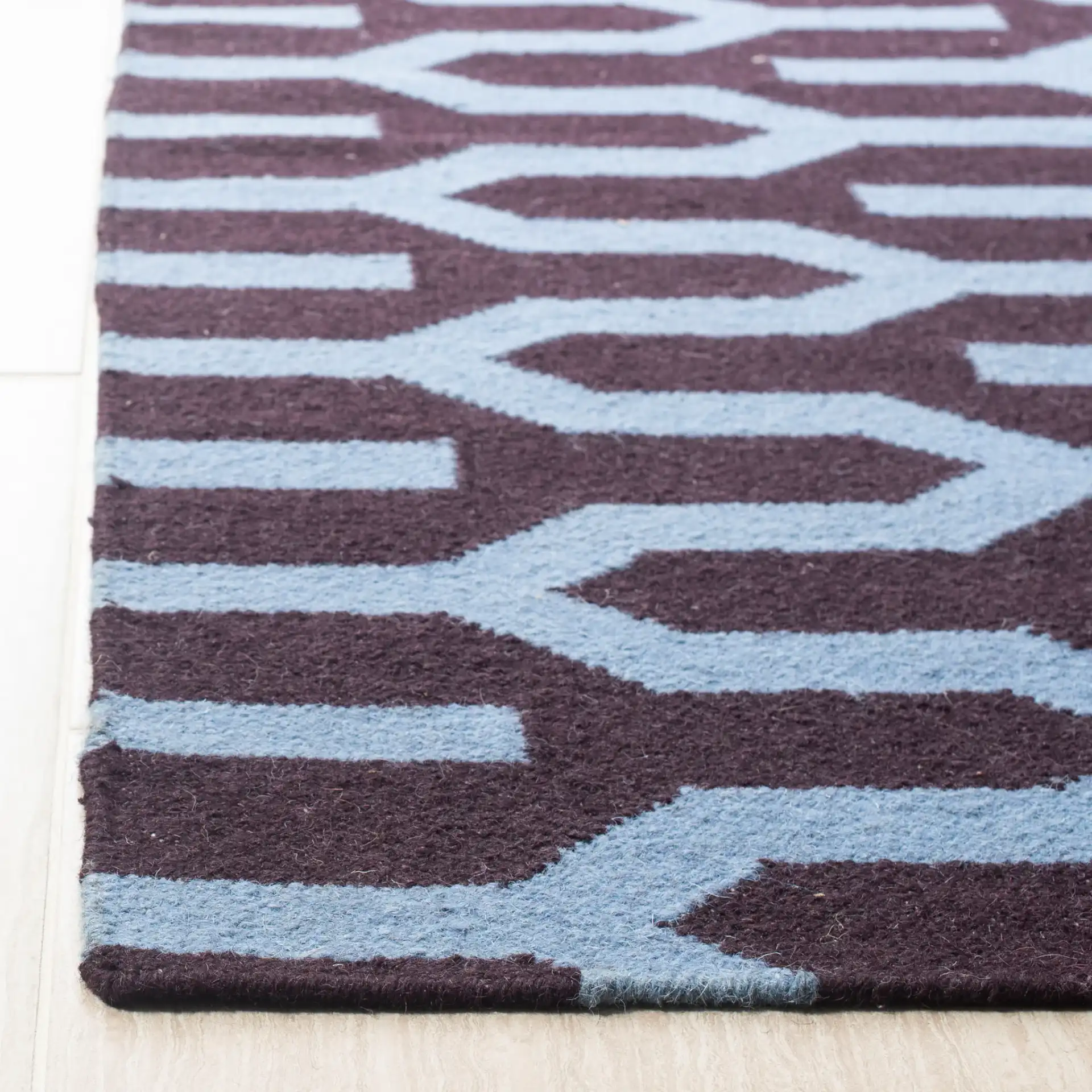 Dhurries Interlocking Chevron Hand-Woven Wool Rug in Purple / Blue in a styled room
