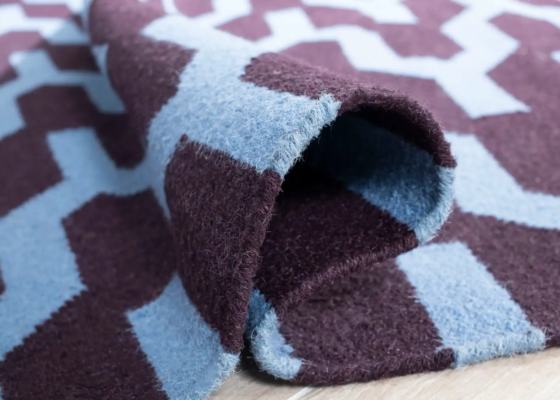 Dhurries Interlocking Chevron Hand-Woven Wool Rug in Purple / Blue in a styled room