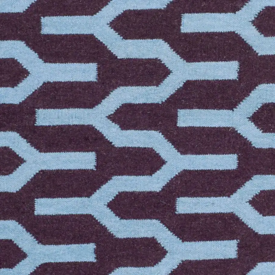 Dhurries Interlocking Chevron Hand-Woven Wool Rug in Purple / Blue in a styled room