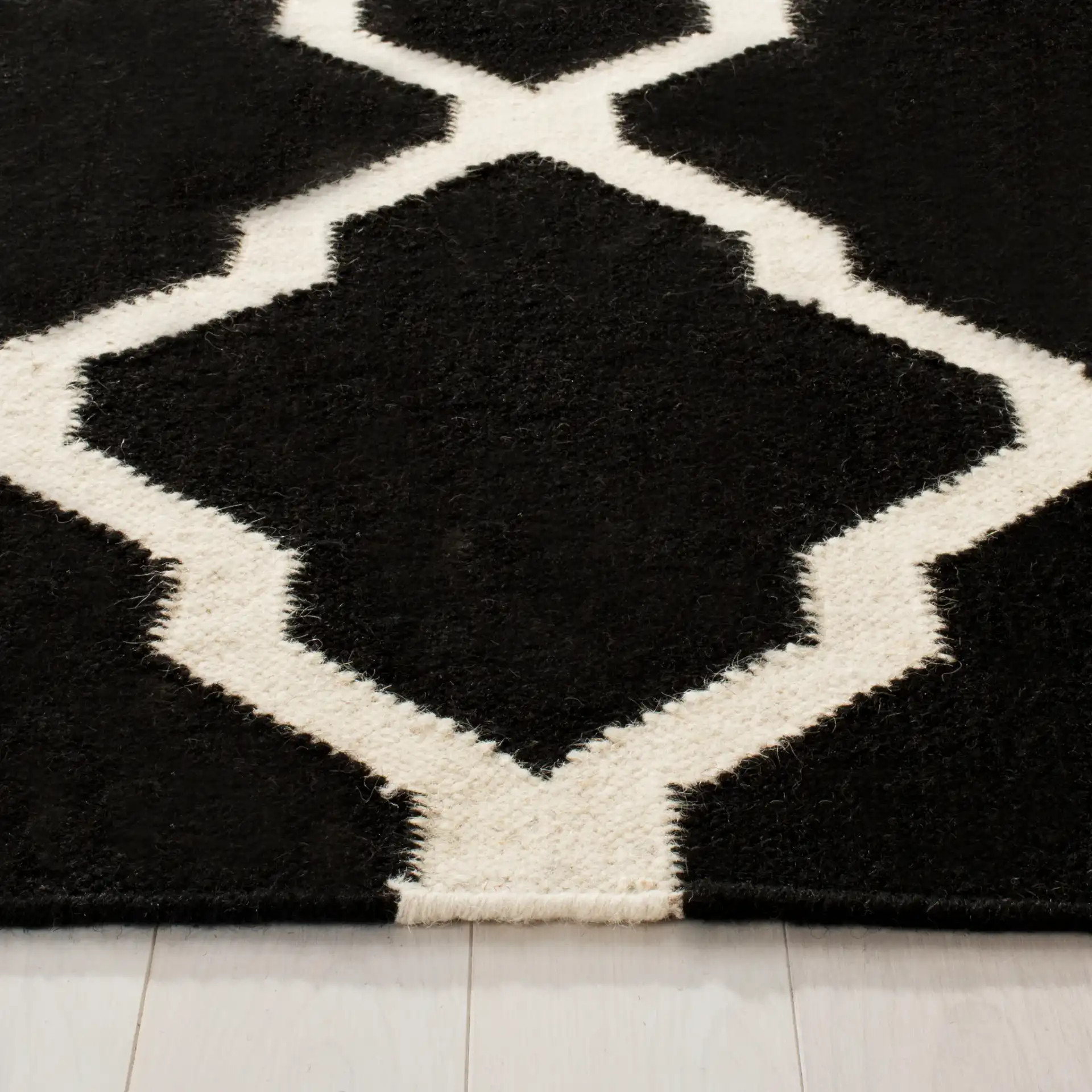 Dhurries Lattice Hand-Woven Wool Rug in Black / Ivory in a styled room