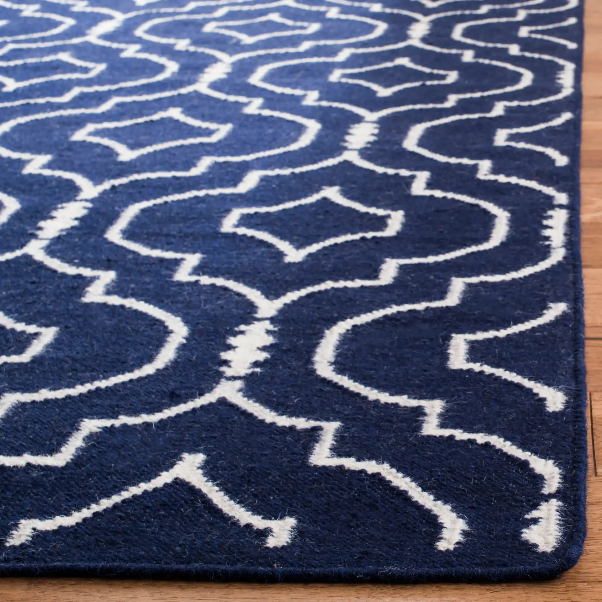 Dhurries Nested Trellis Hand-Woven Wool Rug in Navy / Ivory in a styled room