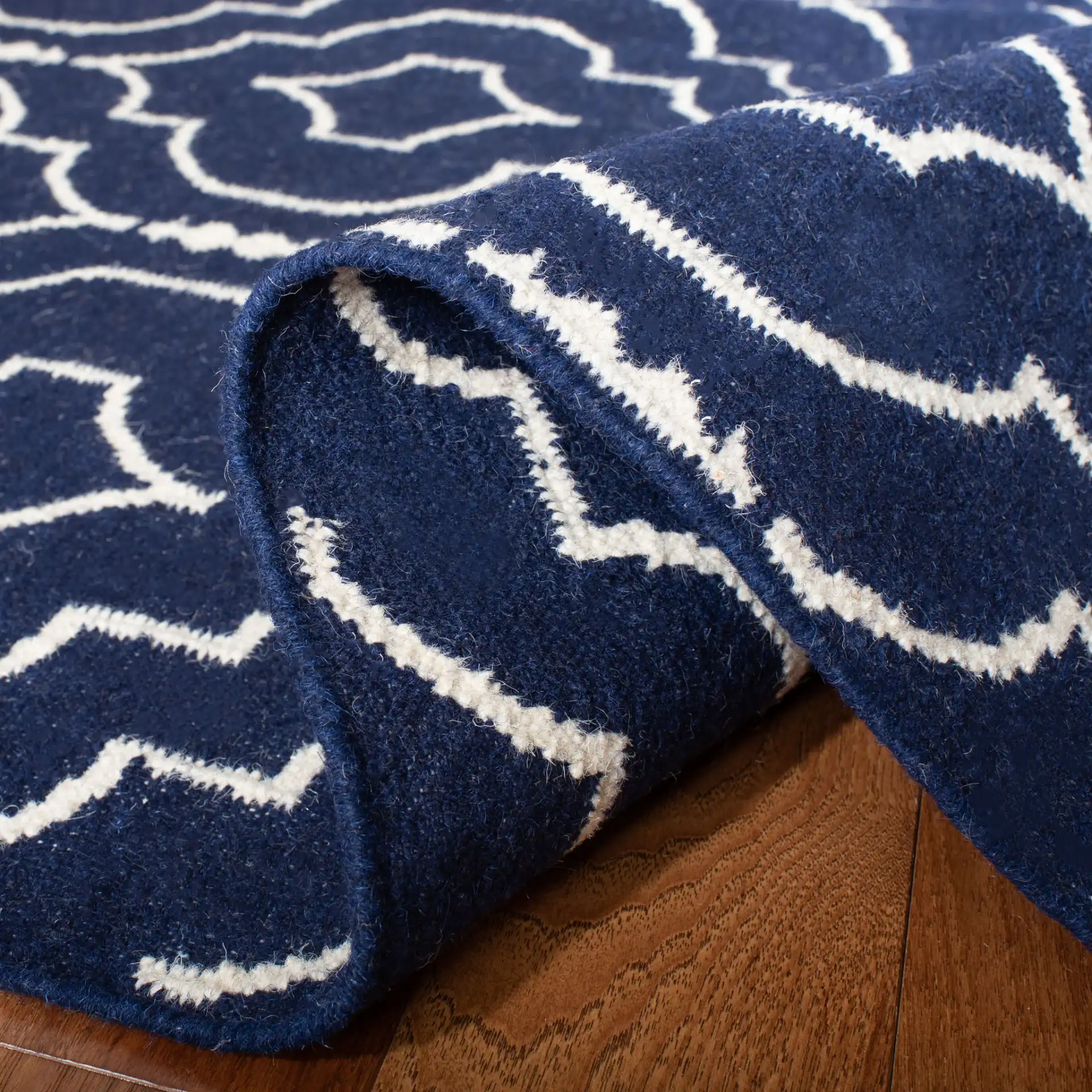 Dhurries Nested Trellis Hand-Woven Wool Rug in Navy / Ivory in a styled room