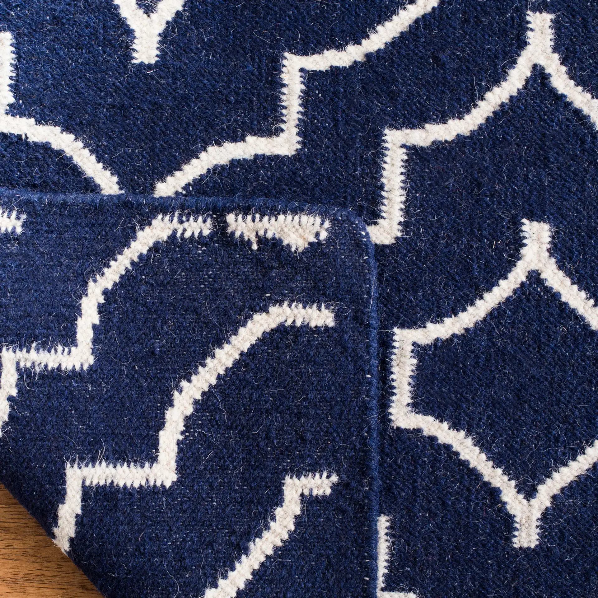 Dhurries Nested Trellis Hand-Woven Wool Rug in Navy / Ivory in a styled room