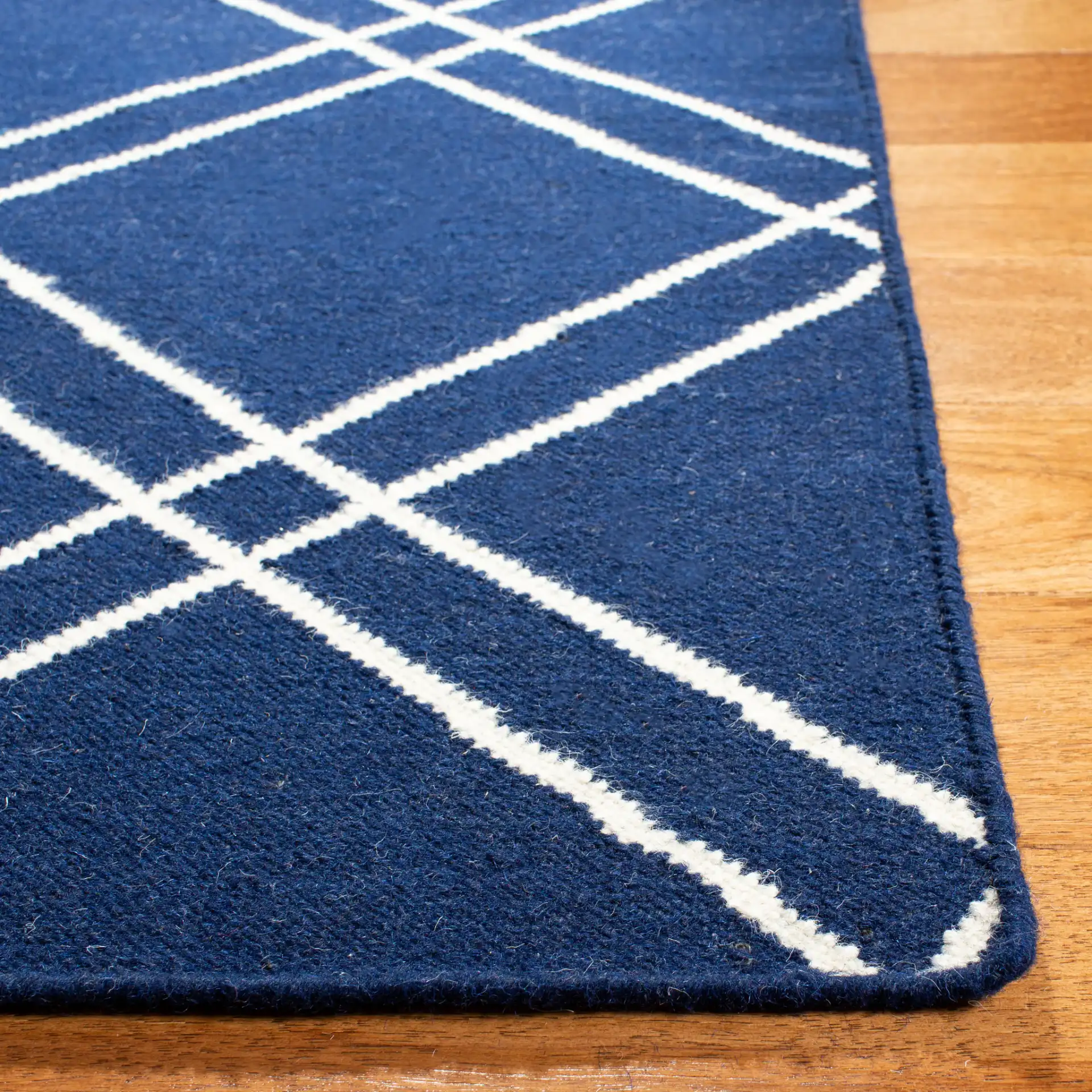 Dhurries Double Diamond Hand-Woven Wool Rug in Navy / Ivory in a styled room