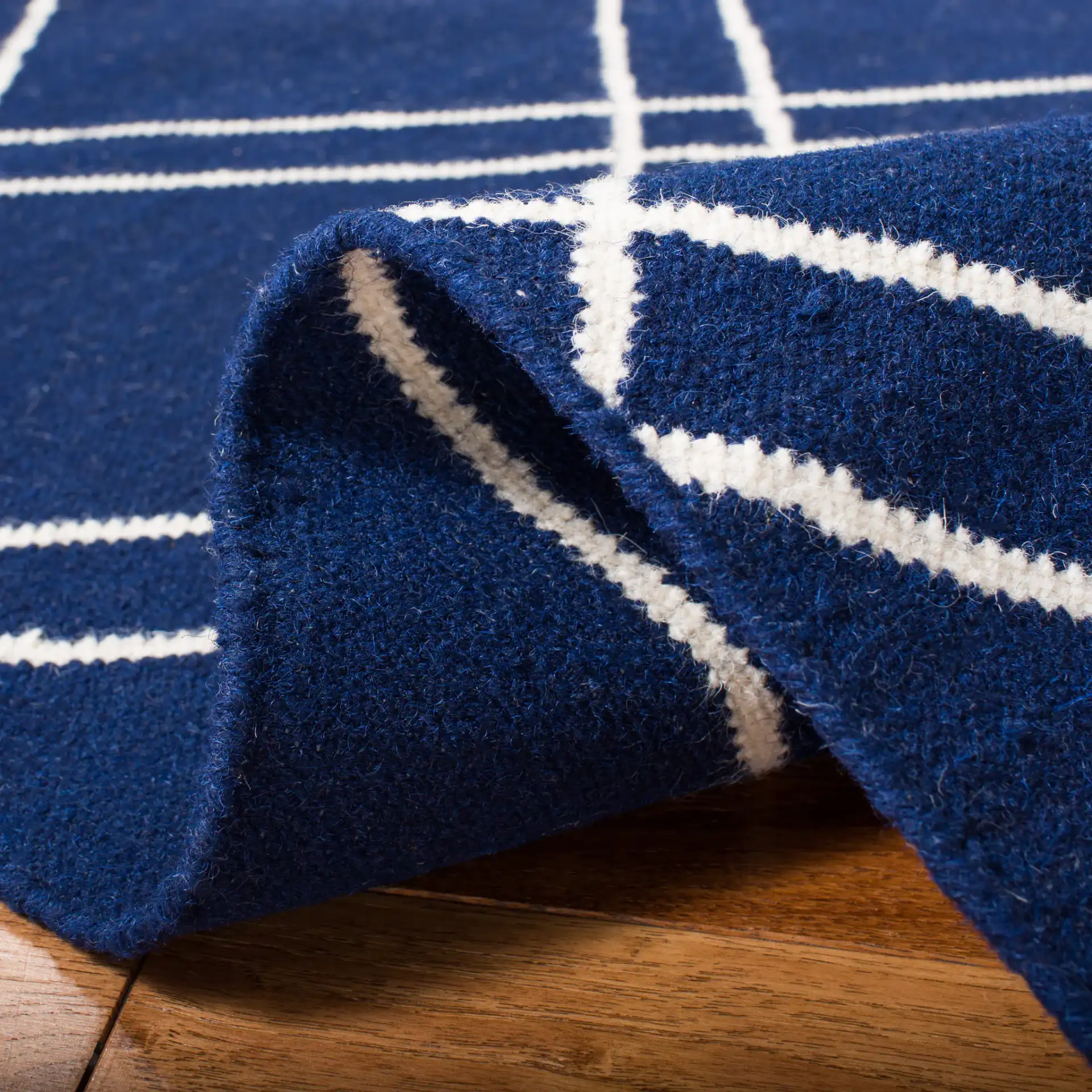 Dhurries Double Diamond Hand-Woven Wool Rug in Navy / Ivory in a styled room