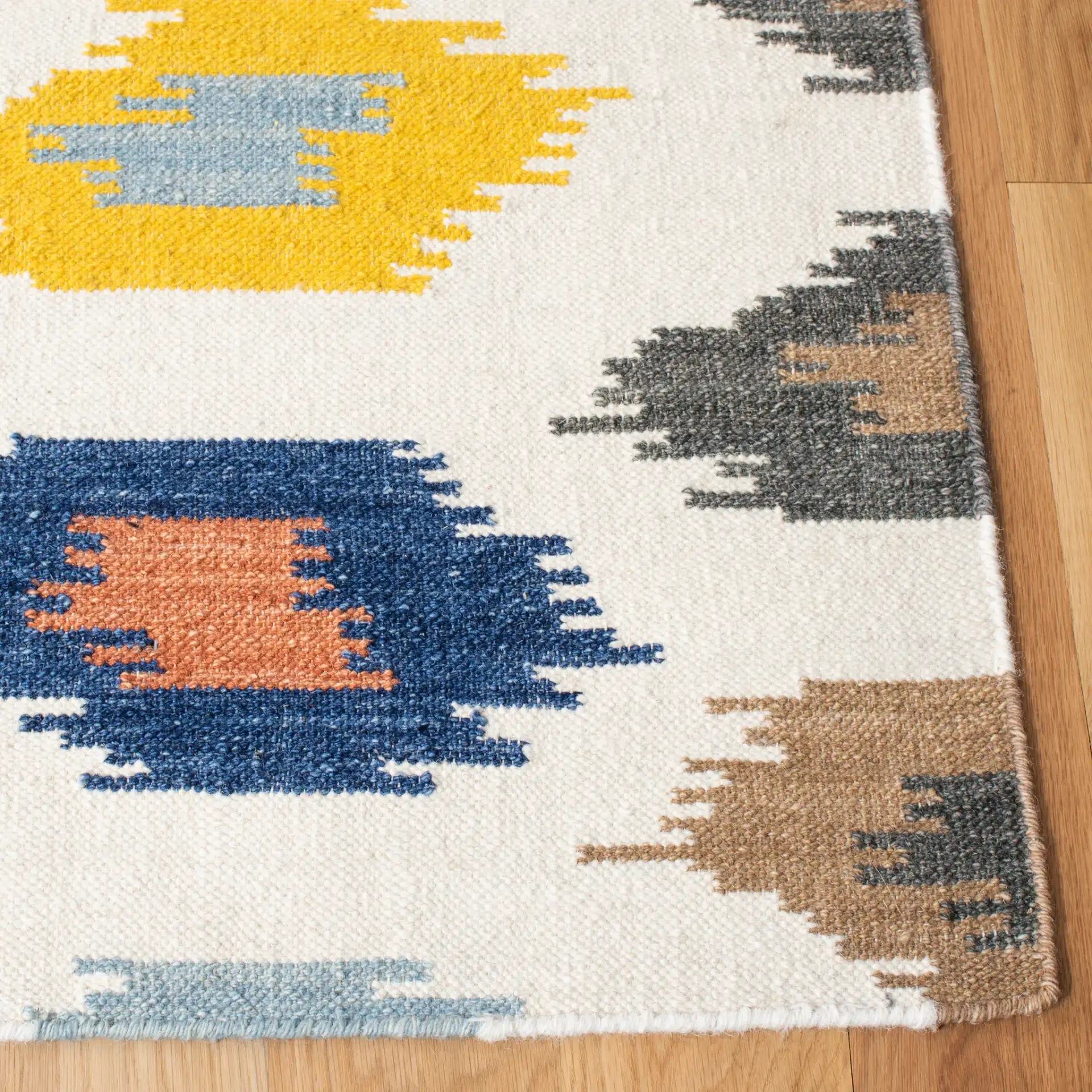 Dhurries Ikat Diamond Hand-Woven Wool Rug in Ivory / Multicolor in a styled room