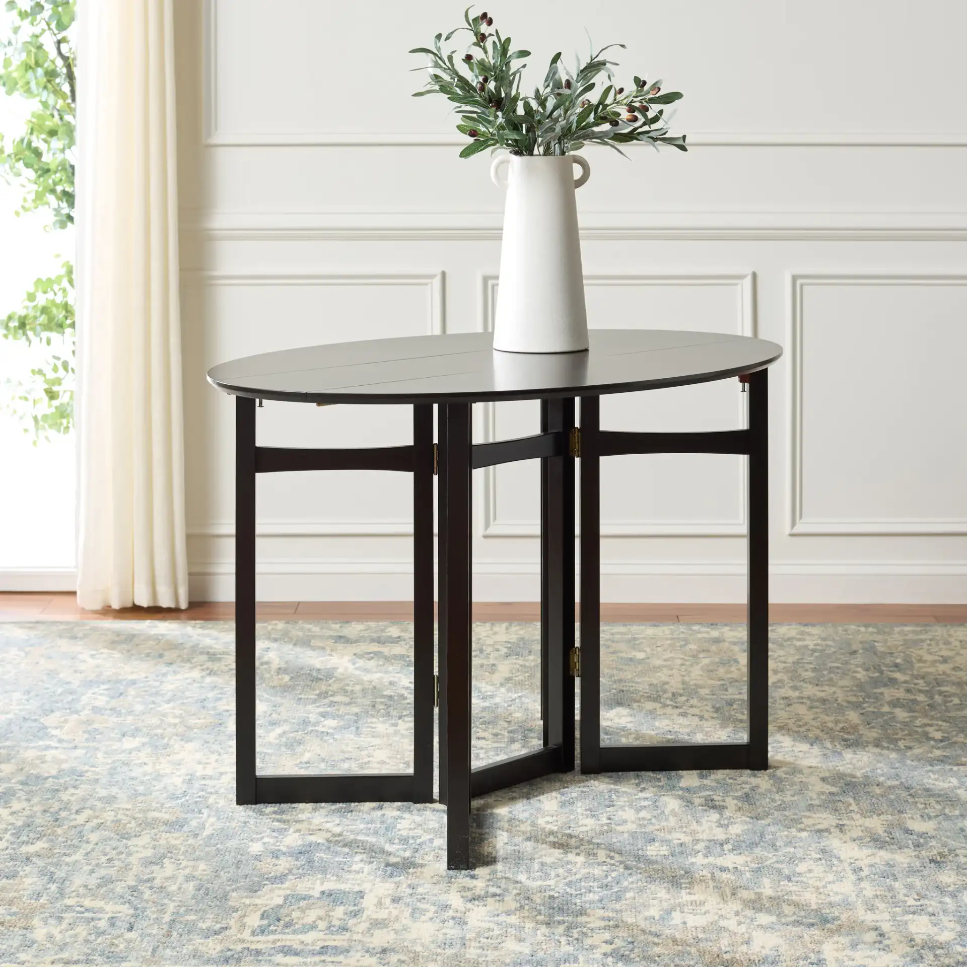 Roz Folding Round Dining Table in Black in a styled room