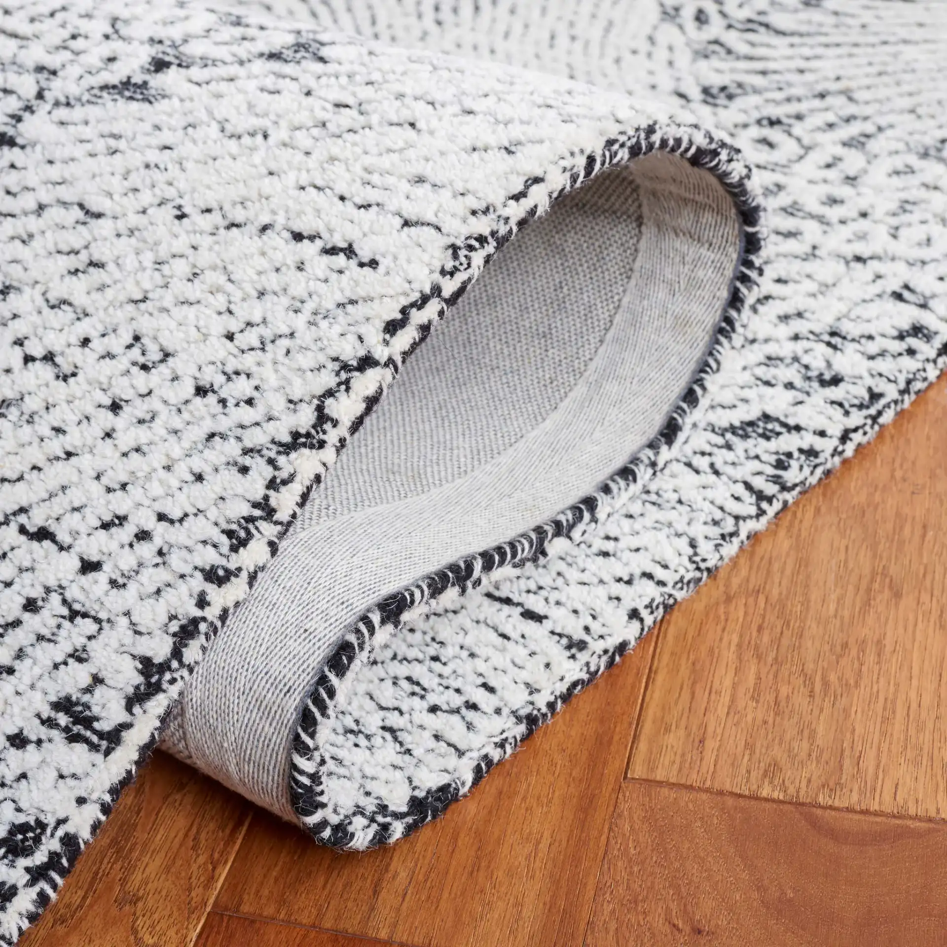 Ebony Wavy Chevron Hand-Tufted Wool Rug in Black / Ivory in a styled room