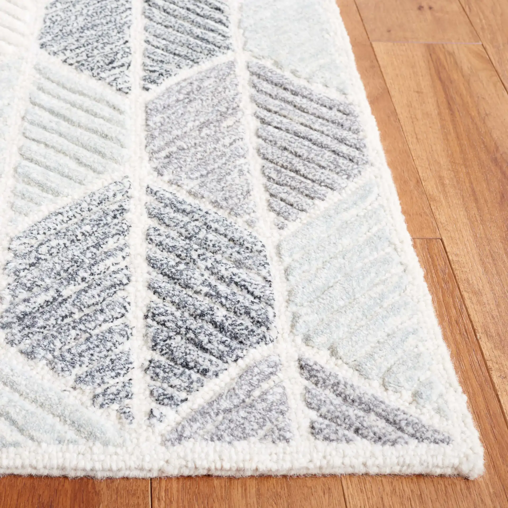Ebony Leaf Hand-Tufted Rug in Gray / Ivory in a styled room
