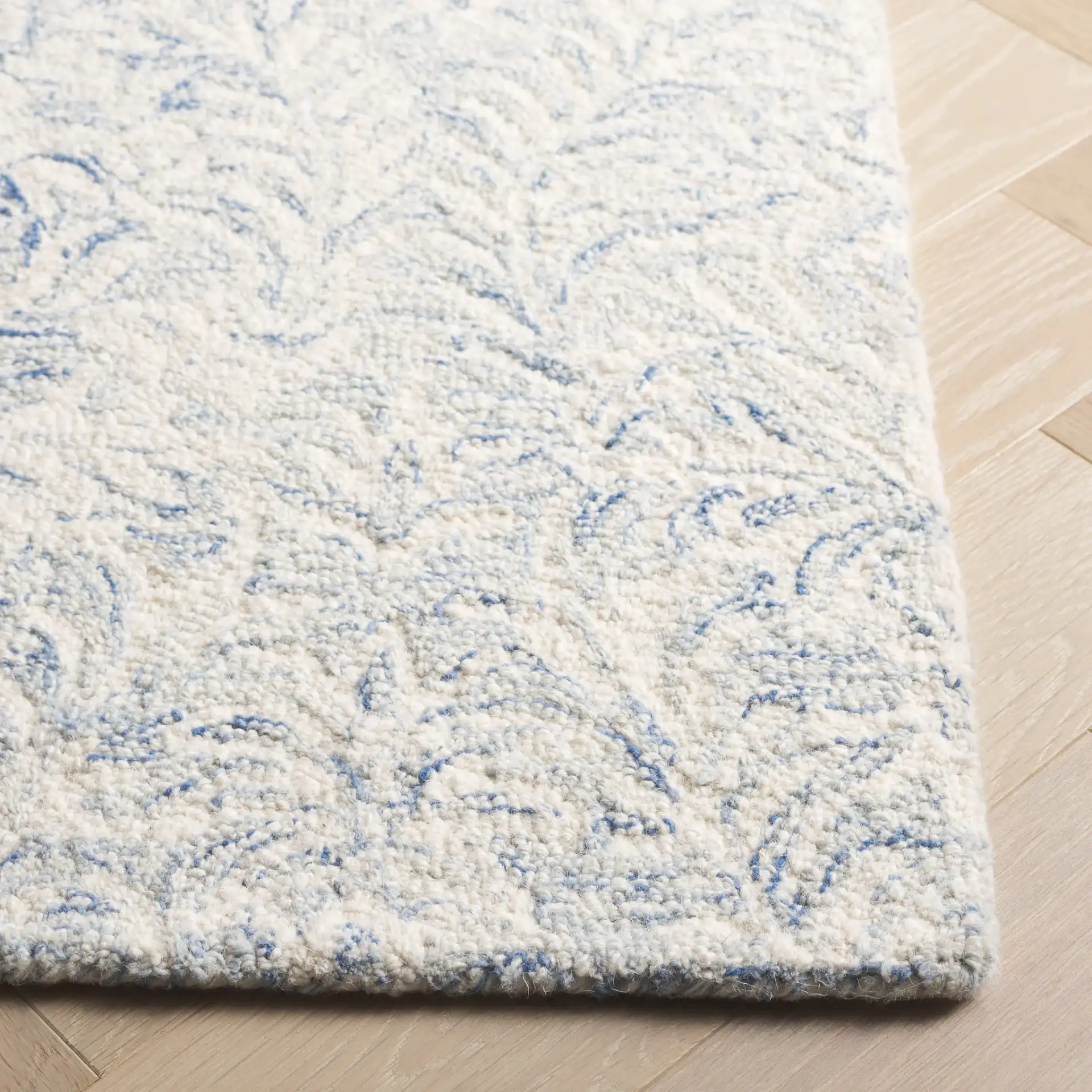 Ebony Leafy Frond Hand-Tufted Wool Rug in Blue / Ivory in a styled room