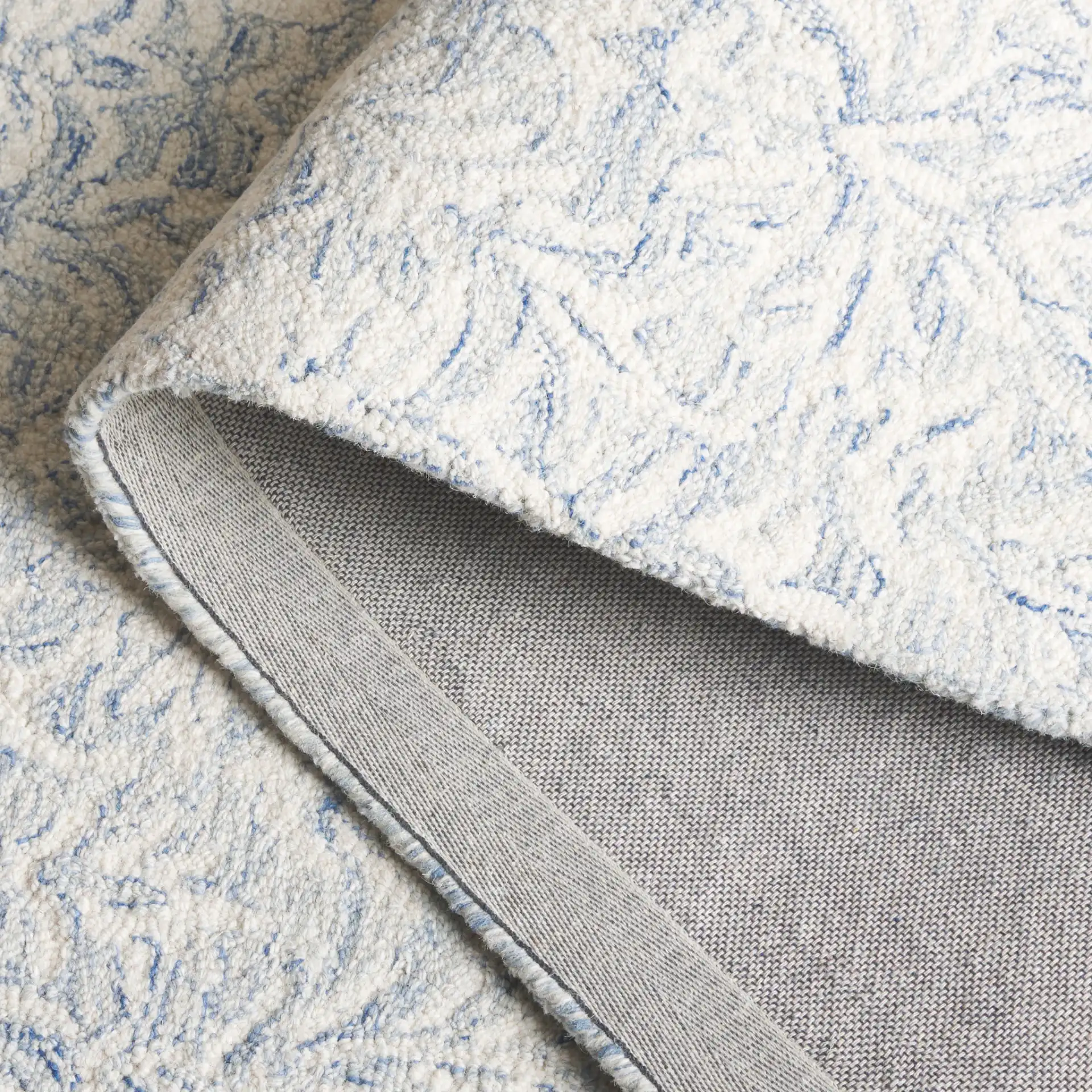 Ebony Leafy Frond Hand-Tufted Wool Rug in Blue / Ivory in a styled room