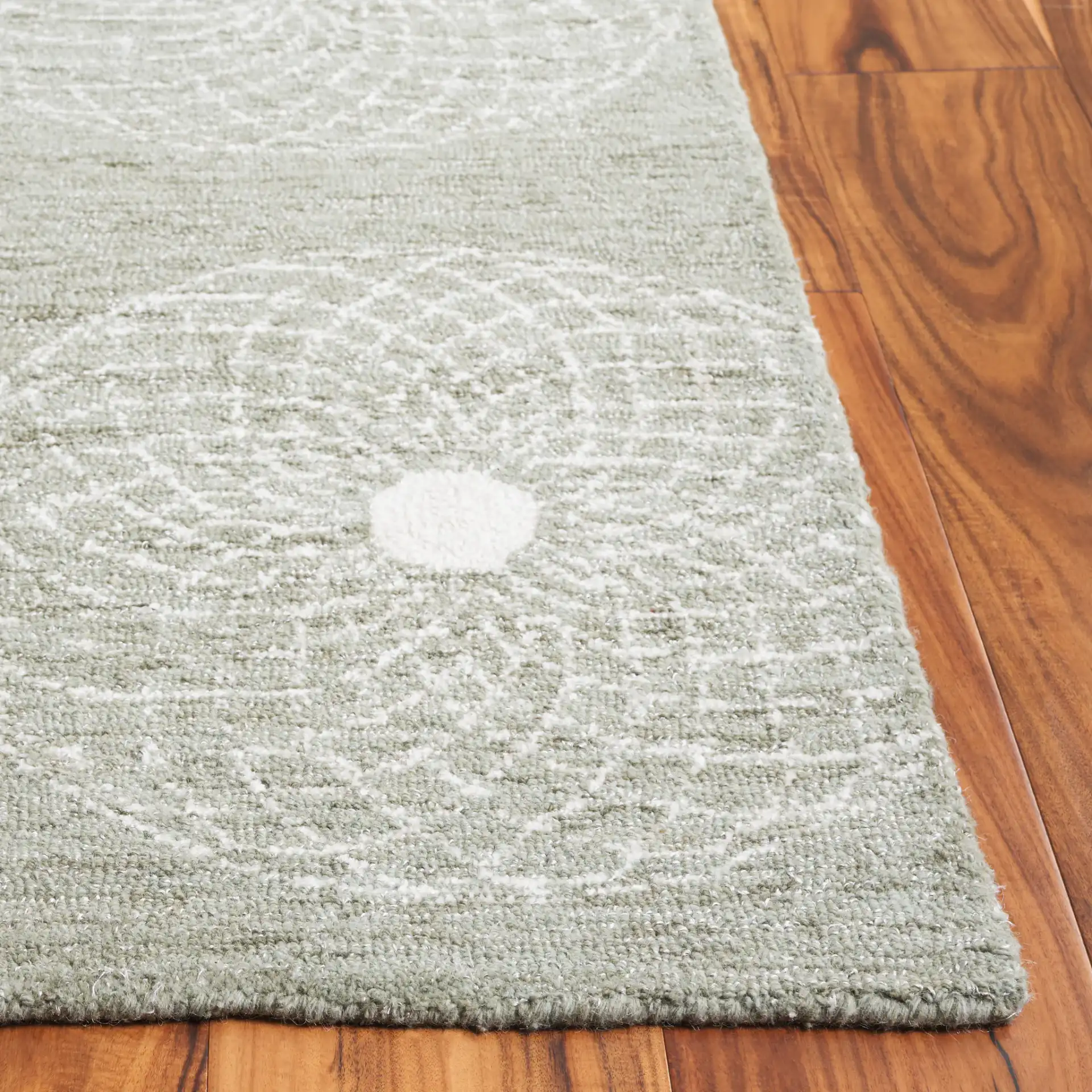 Ebony Swirling Circle Hand-Tufted Rug in Sage / Ivory in a styled room