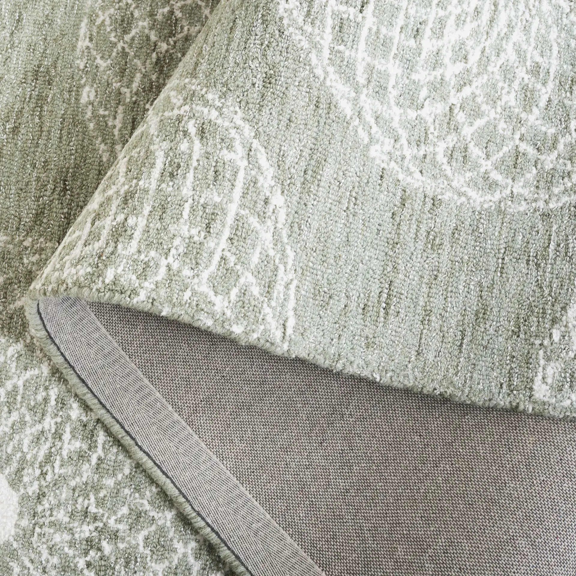 Ebony Swirling Circle Hand-Tufted Rug in Sage / Ivory in a styled room
