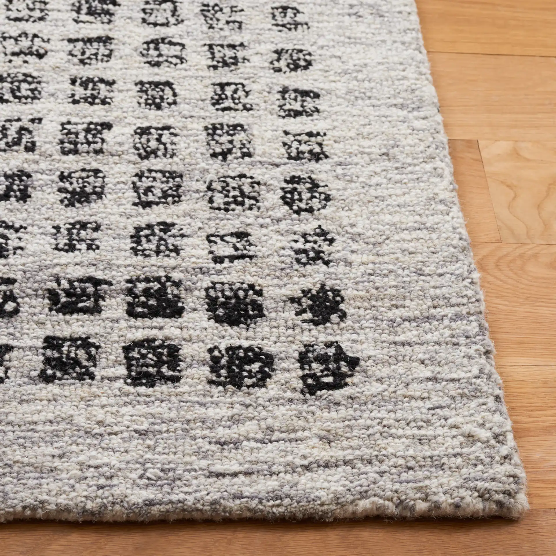 Ebony Dotted Grid Hand-Tufted Wool Rug in Silver / Black in a styled room