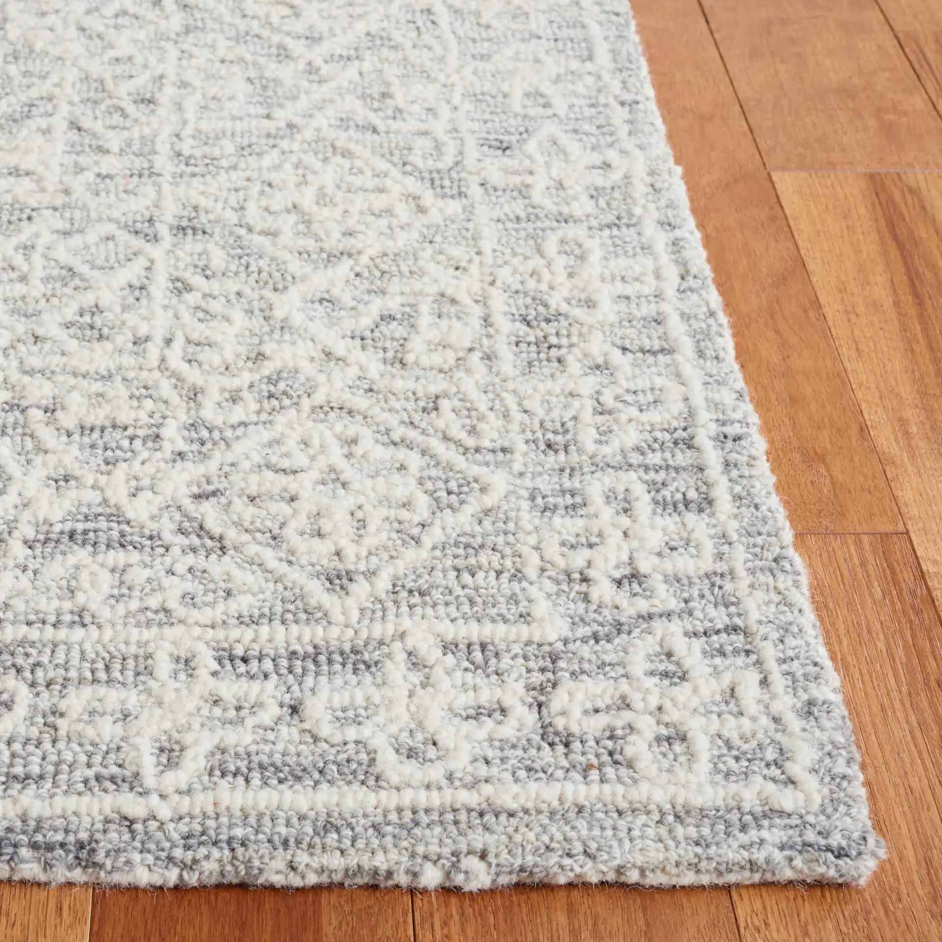 Ebony Bordered Trellis Hand-Tufted Wool Rug in Gray / Ivory in a styled room