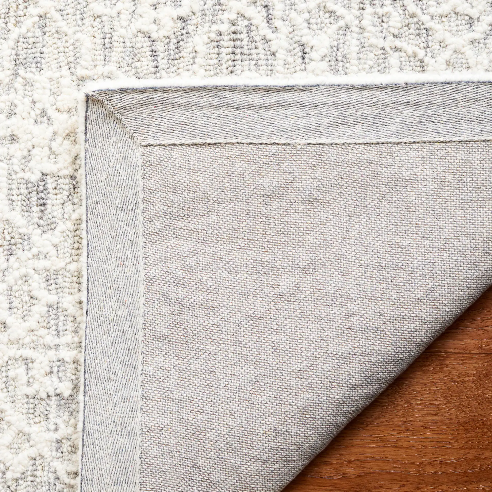 Ebony Bordered Trellis Hand-Tufted Wool Rug in Gray / Ivory in a styled room