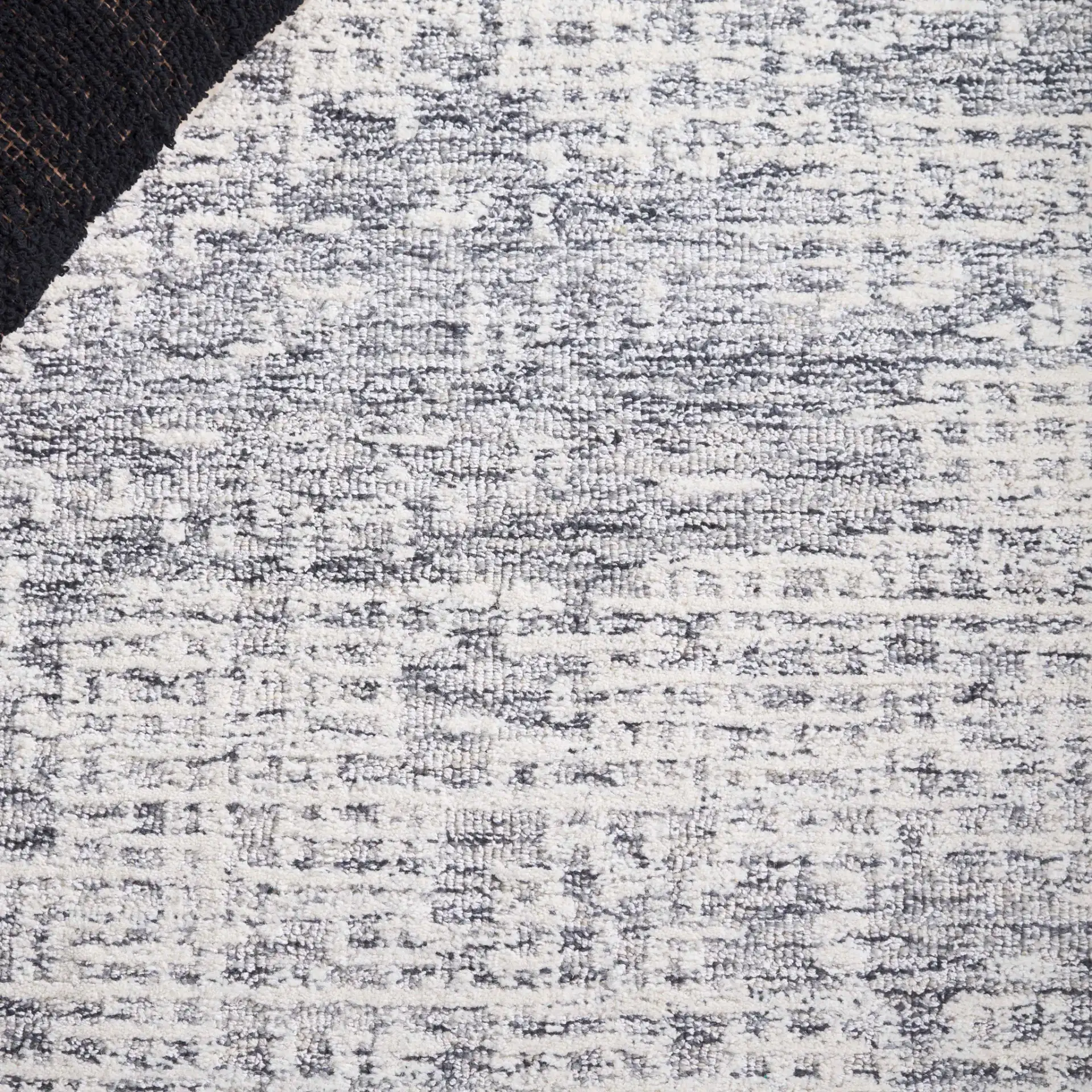 Ebony Distressed Grid Hand-Tufted Wool Rug in Ivory / Gray in a styled room