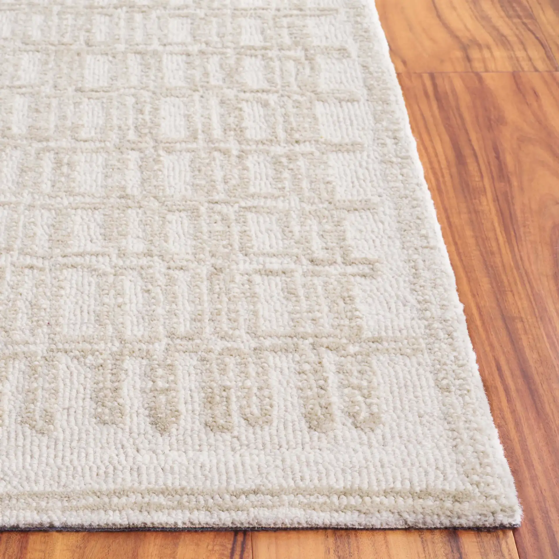 Ebony Bordered Grid Hand-Tufted Wool Rug in Ivory / Beige in a styled room
