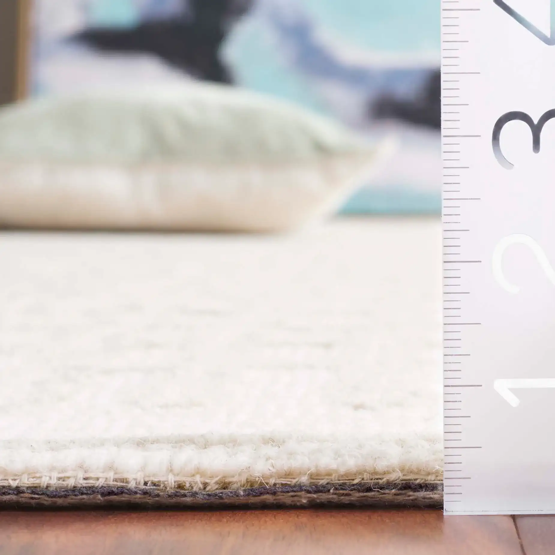 Ebony Bordered Grid Hand-Tufted Wool Rug in Ivory / Beige in a styled room