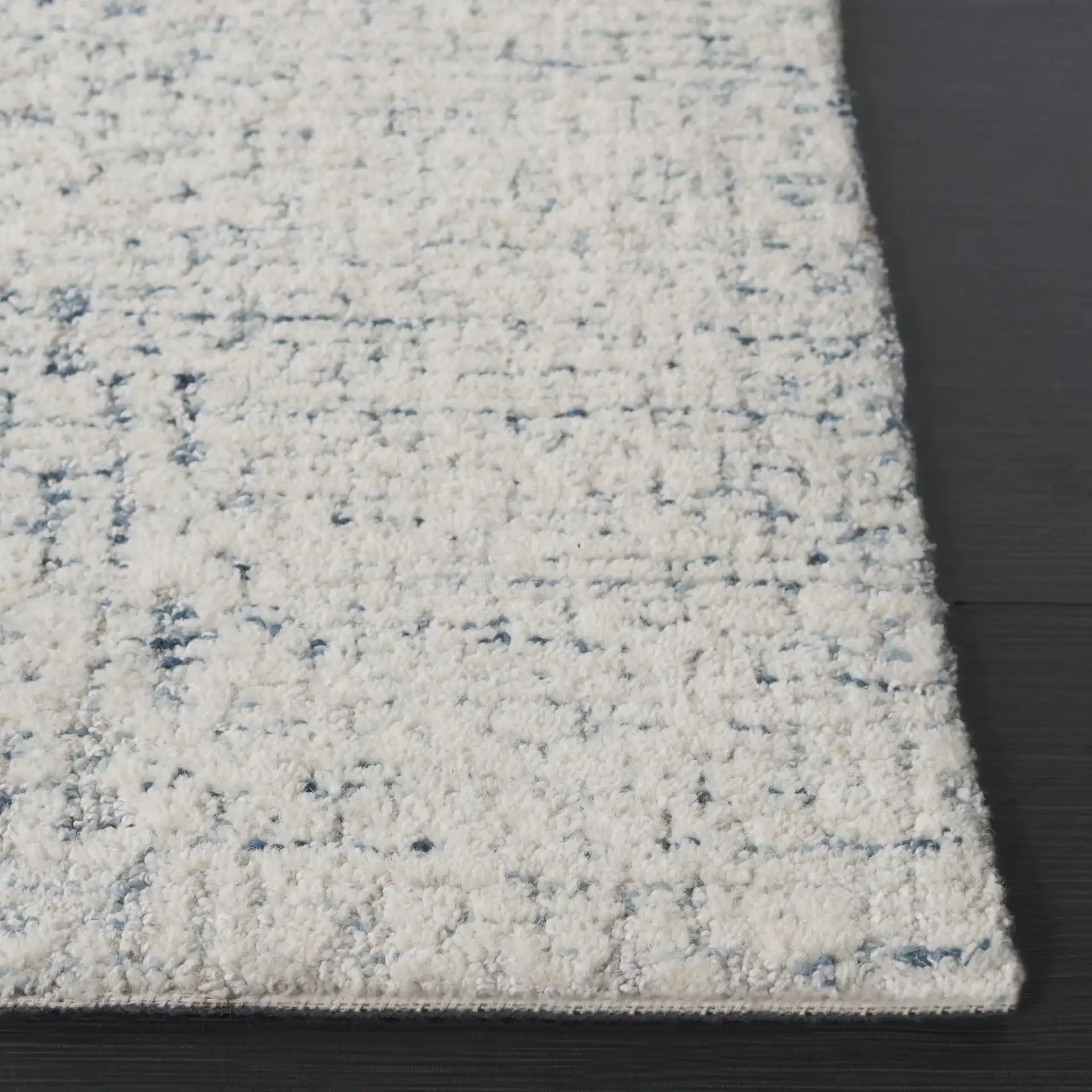 Ebony Textured Patchwork Hand-Tufted Rug in Ivory / Blue in a styled room