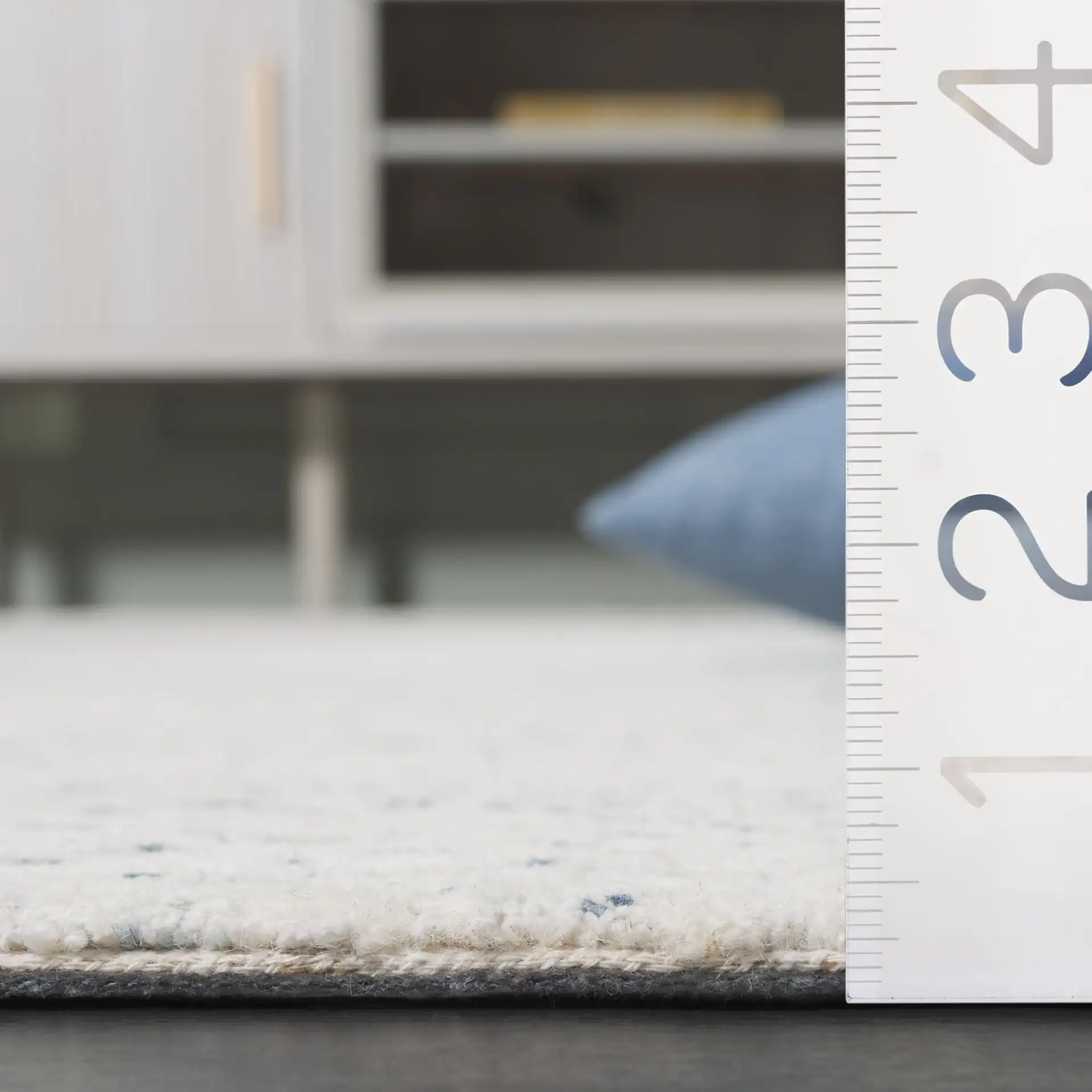 Ebony Textured Patchwork Hand-Tufted Rug in Ivory / Blue in a styled room