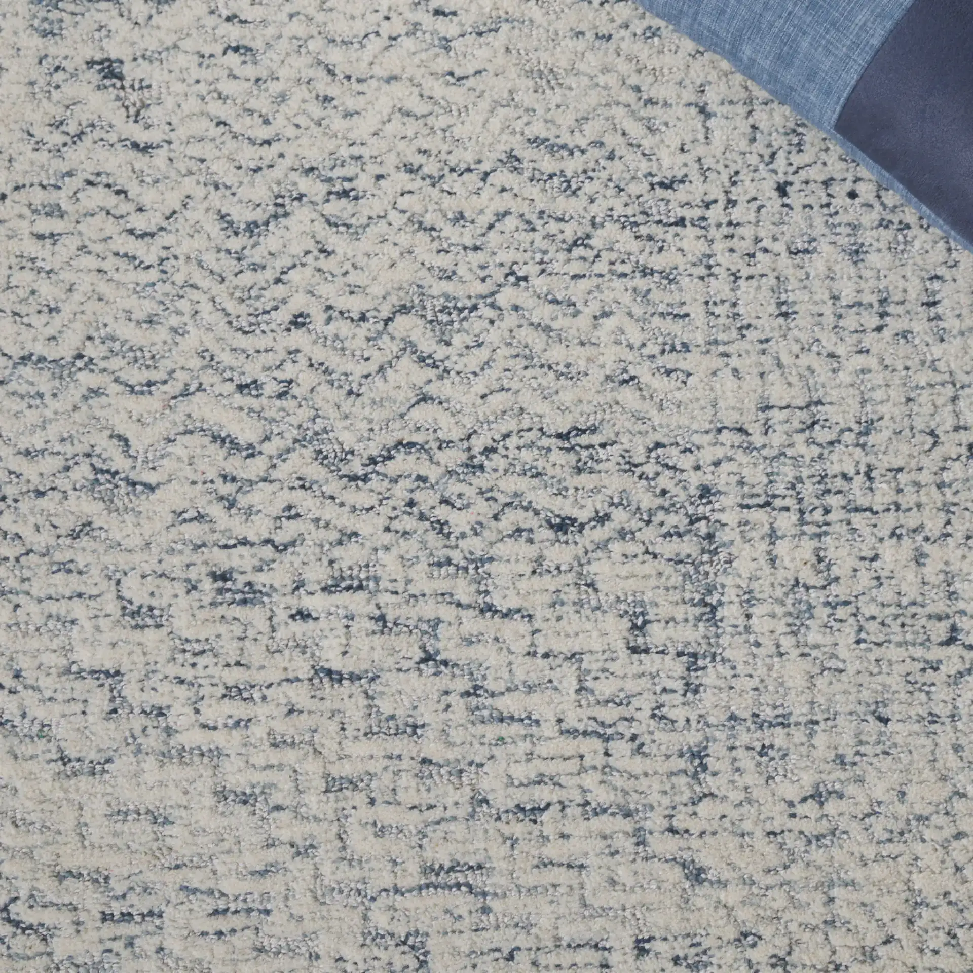 Ebony Textured Patchwork Hand-Tufted Rug in Ivory / Blue in a styled room