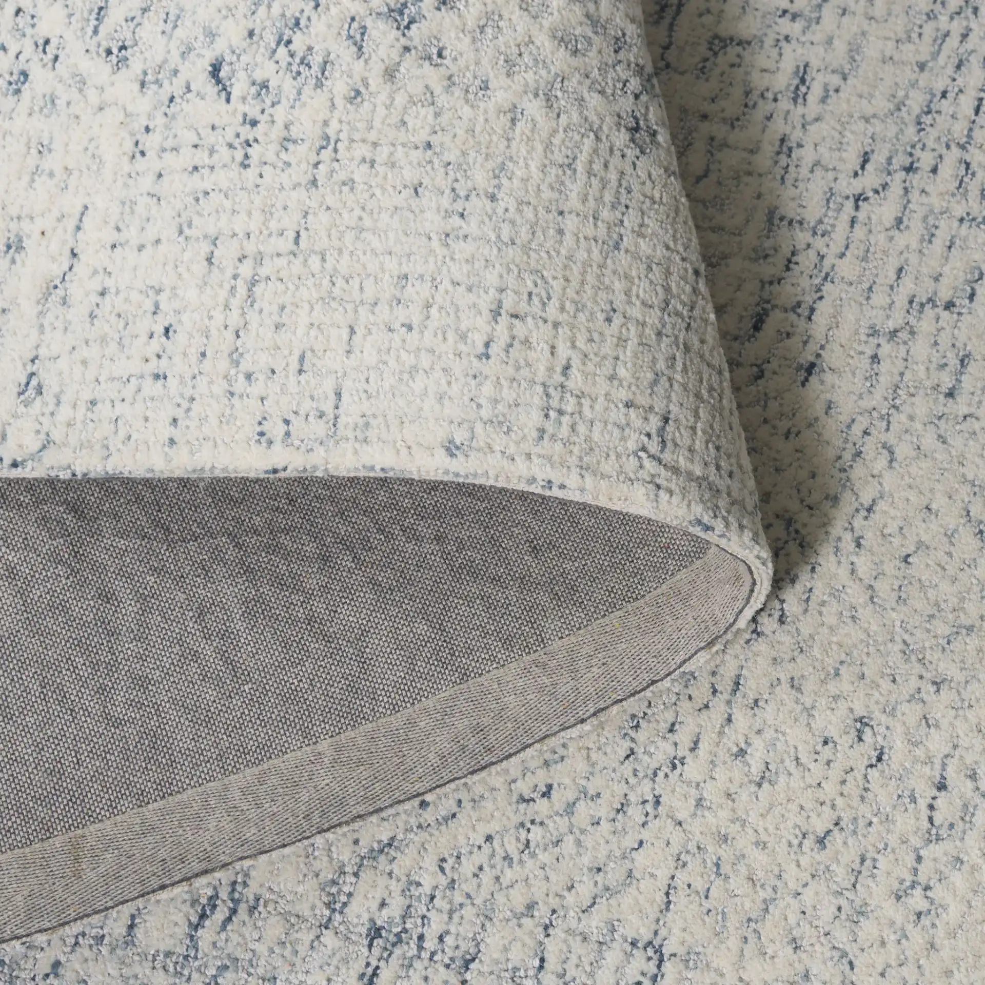 Ebony Textured Patchwork Hand-Tufted Rug in Ivory / Blue in a styled room