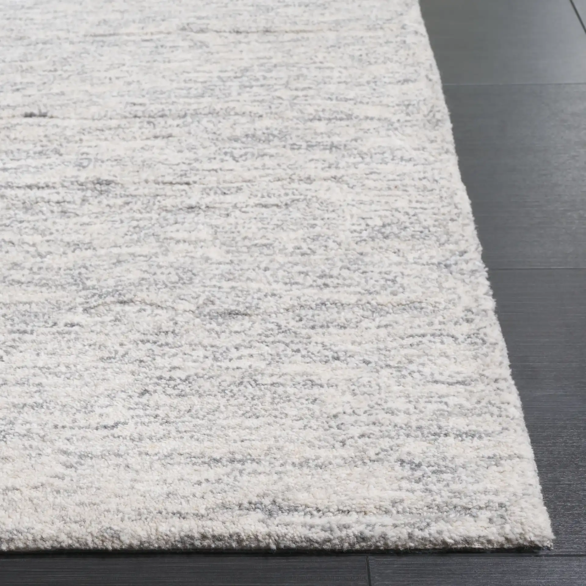 Ebony Horizontal Striated Hand-Tufted Wool Rug in Ivory / Dark Gray in a styled room