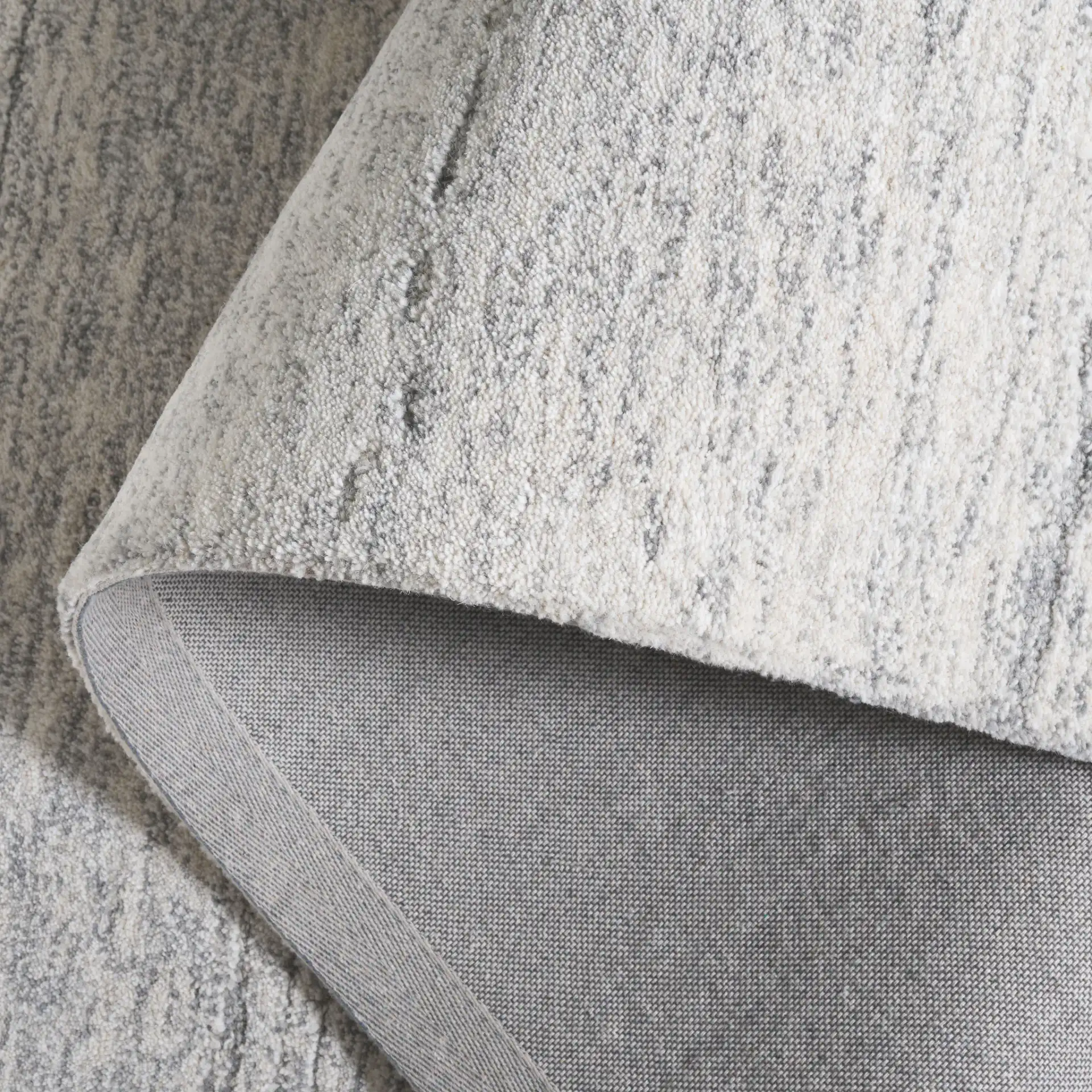 Ebony Horizontal Striated Hand-Tufted Wool Rug in Ivory / Dark Gray in a styled room
