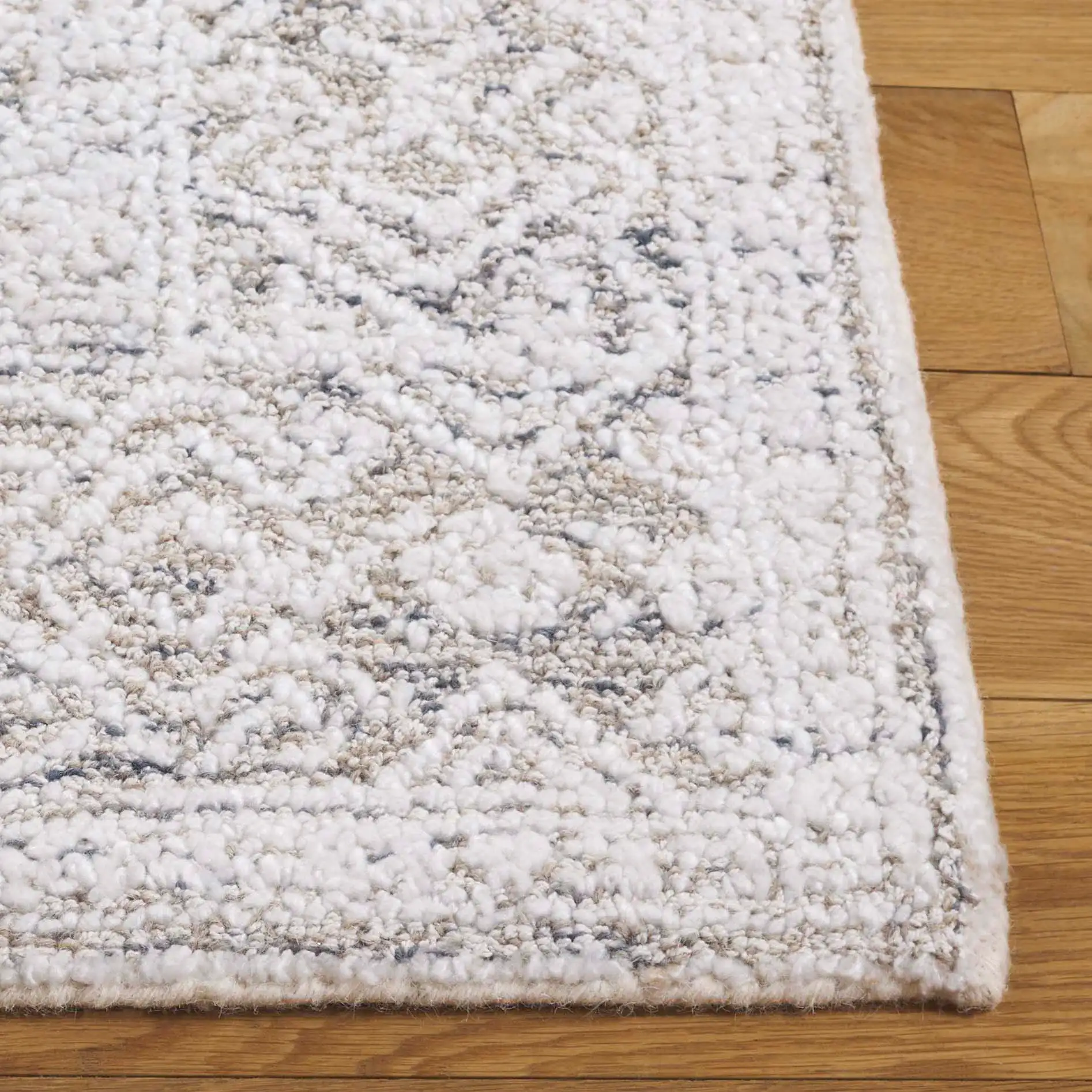 Ebony Diamond Bordered Hand-Tufted Rug in Taupe / Ivory in a styled room