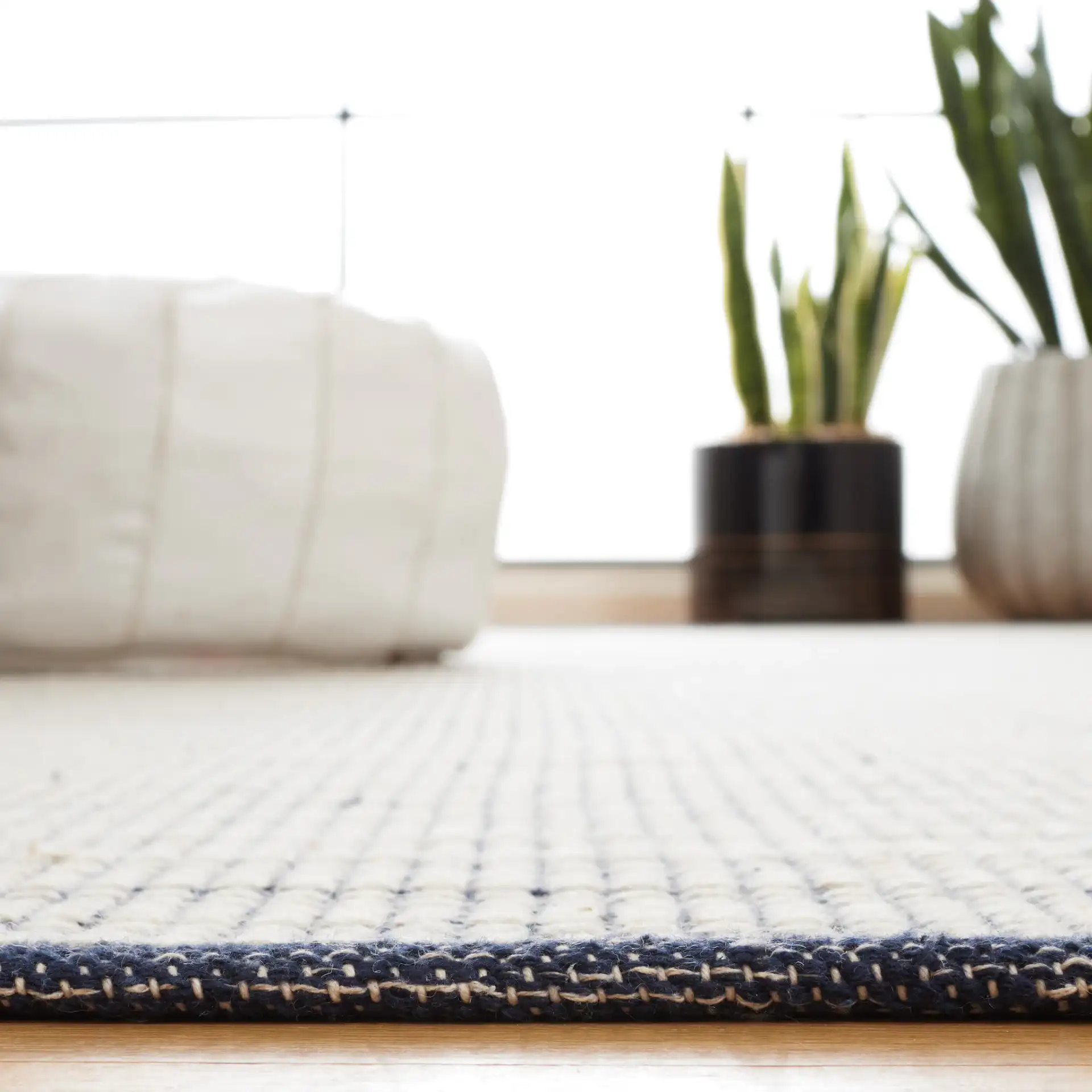 Ebony Striped Border Flatweave Wool Rug in Ivory / Navy in a styled room