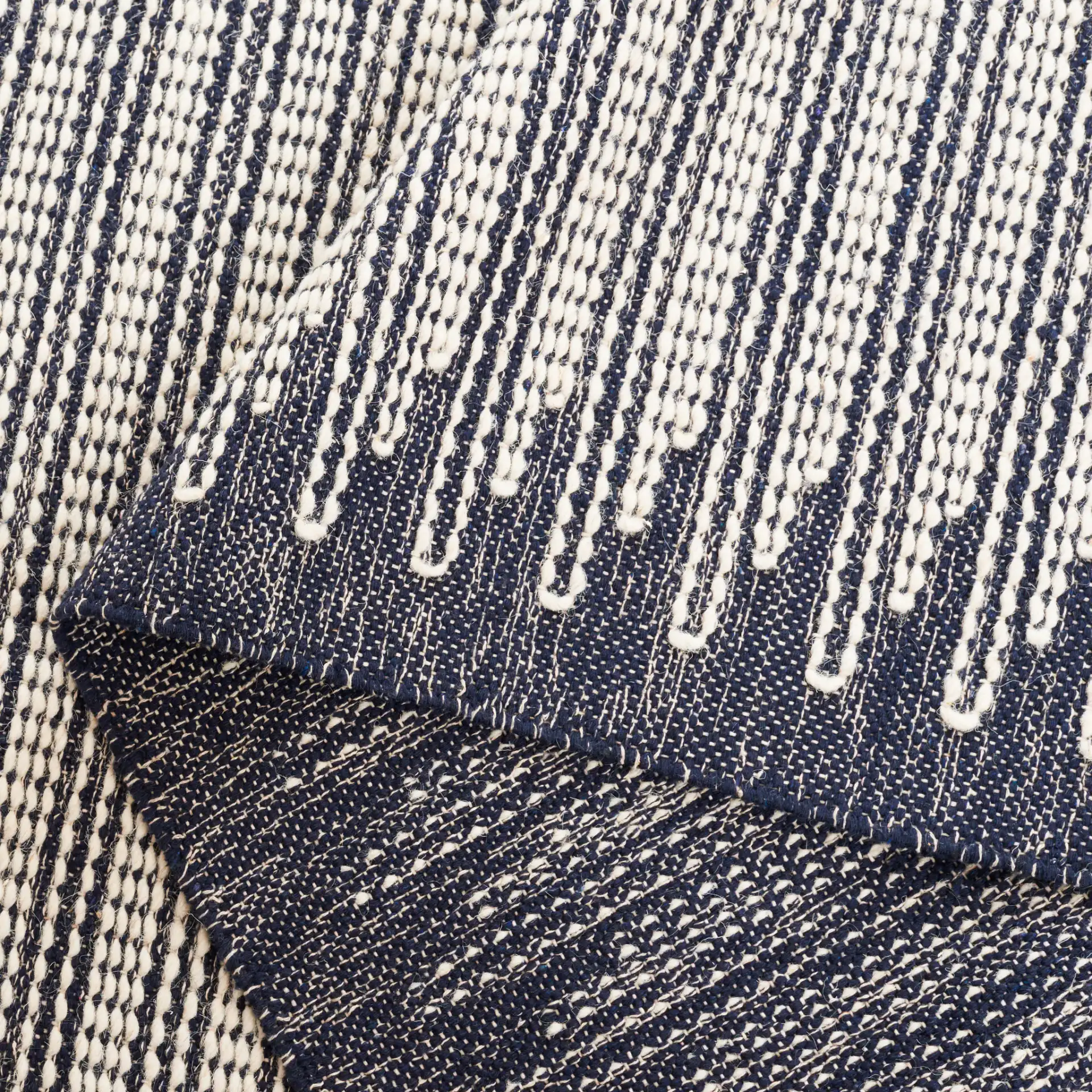 Ebony Striped Border Flatweave Wool Rug in Ivory / Navy in a styled room