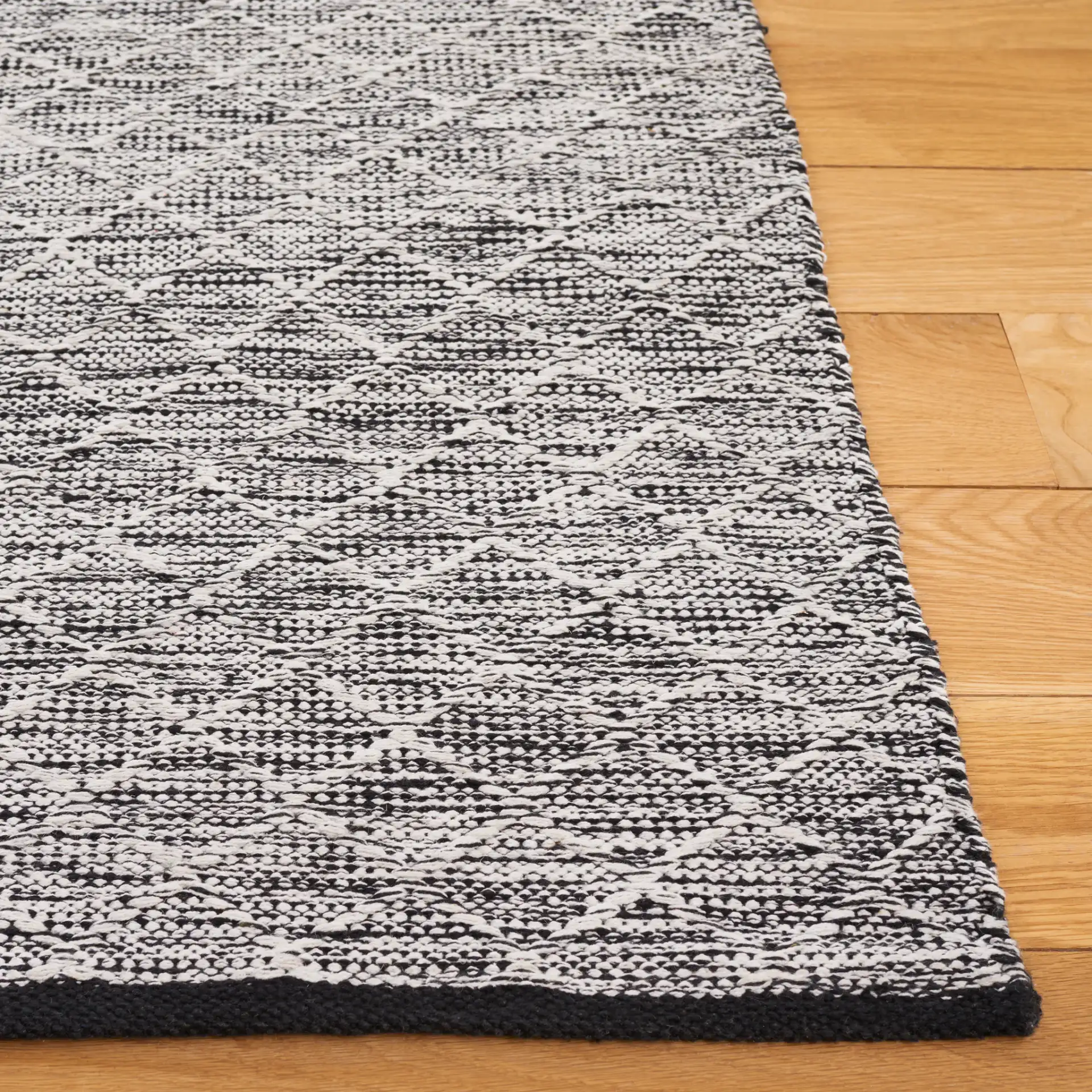 Ebony Diamond Flatweave Cotton Rug in Ivory / Black in a styled room