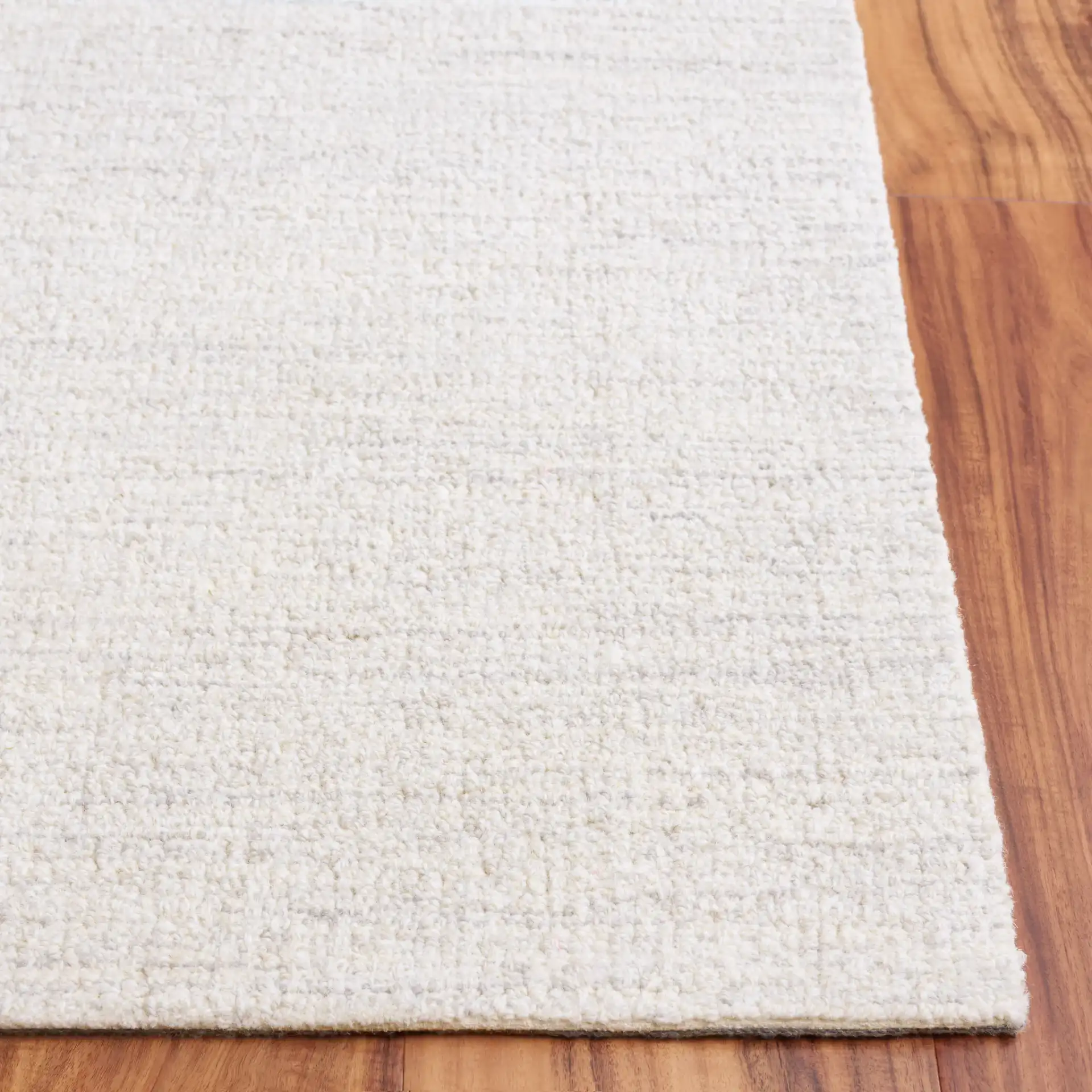 Ebony Solid Hand-Tufted Wool Rug in Light Gray / Ivory in a styled room