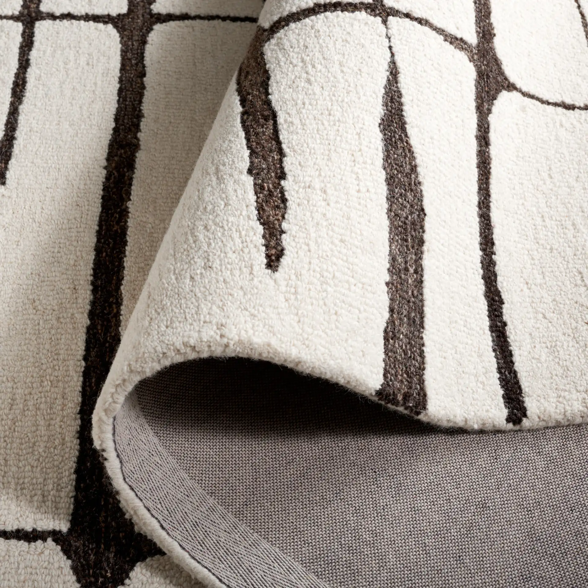 Ebony Linear Grid Hand-Tufted Wool Rug in Ivory / Dark Brown in a styled room