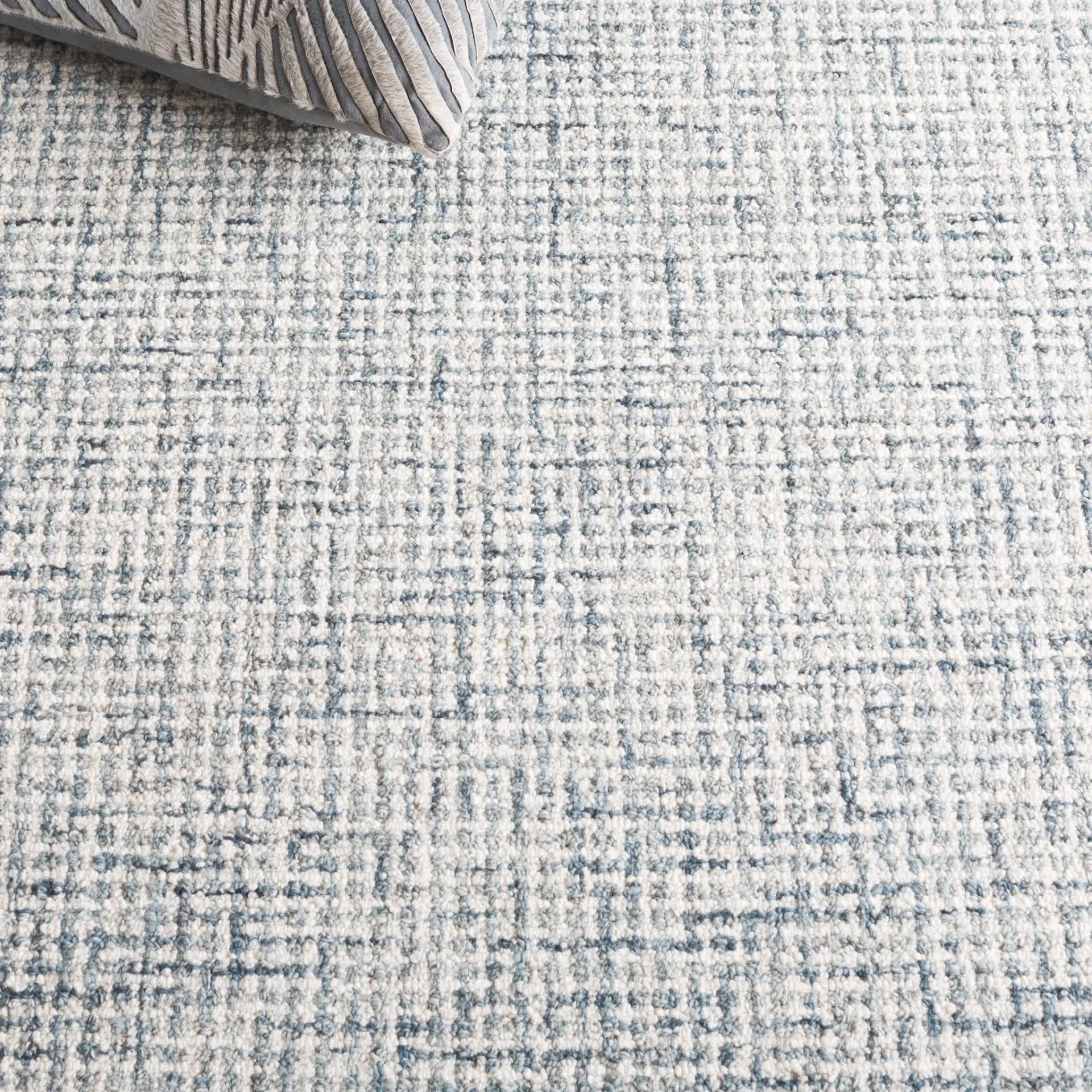 Ebony Grid Border Hand-Tufted Wool Rug in Blue / Ivory in a styled room
