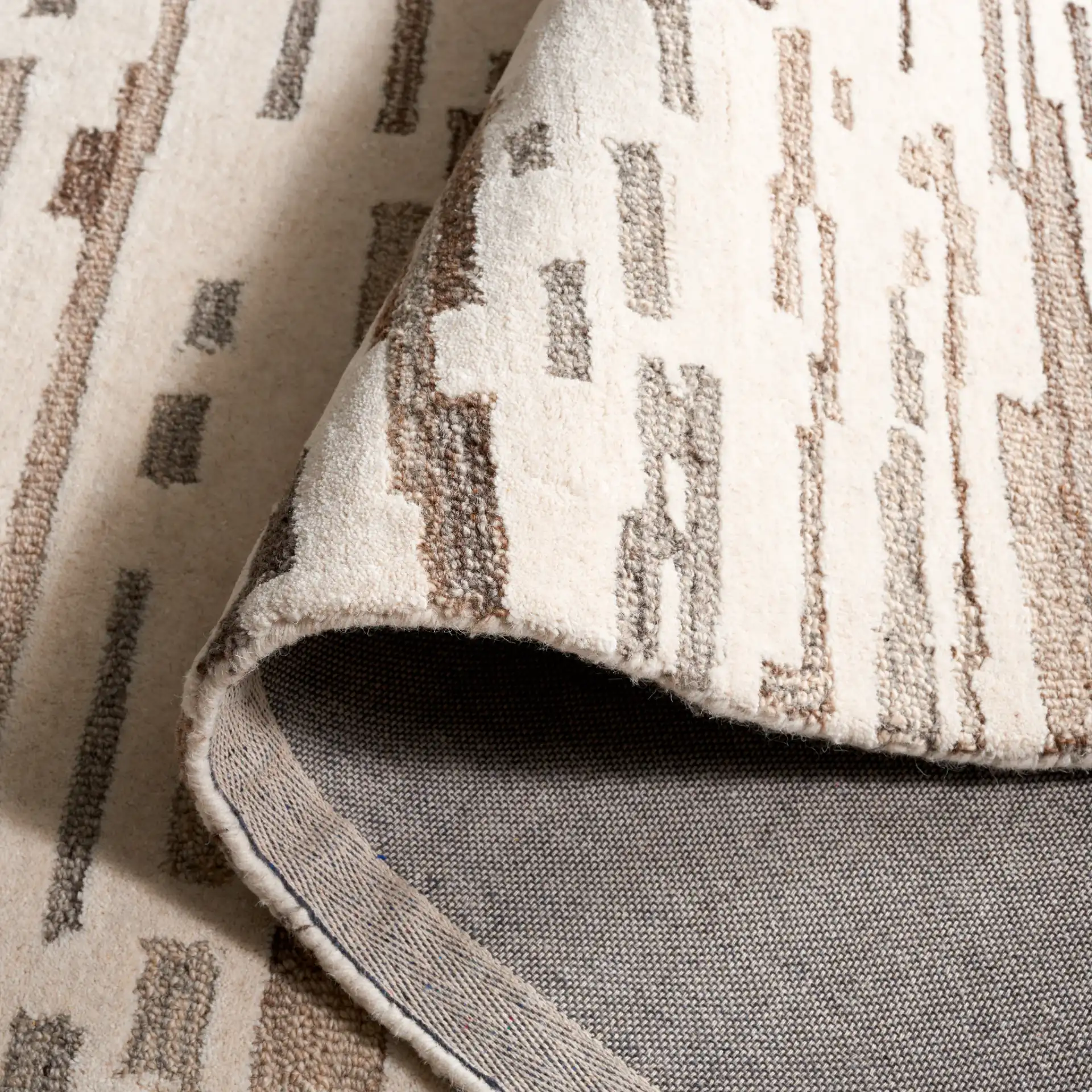 Ebony Linear Abstract Hand-Tufted Wool Rug in Ivory / Gray in a styled room