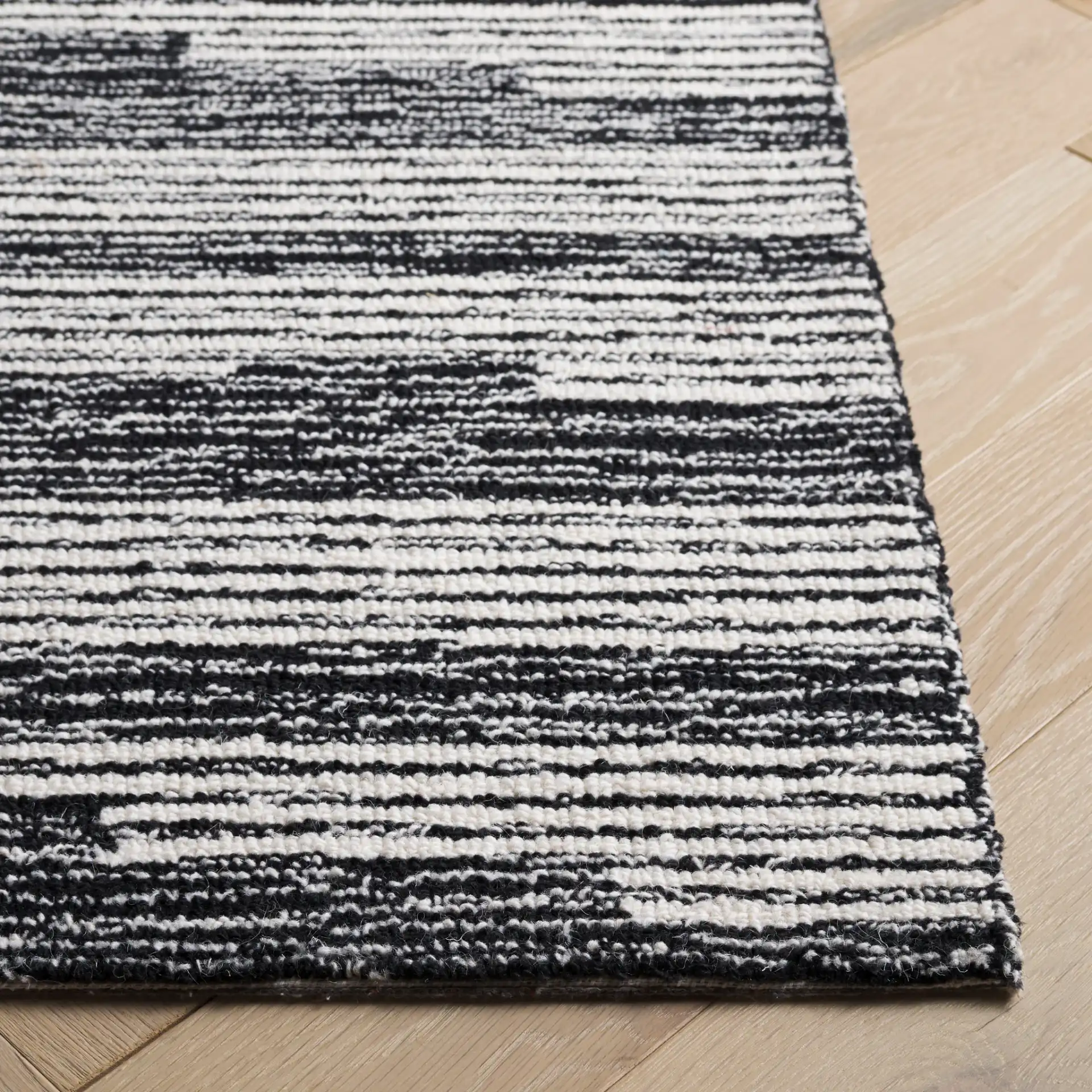 Ebony Broken Stripe Hand-Tufted Wool Rug in Black / Ivory in a styled room