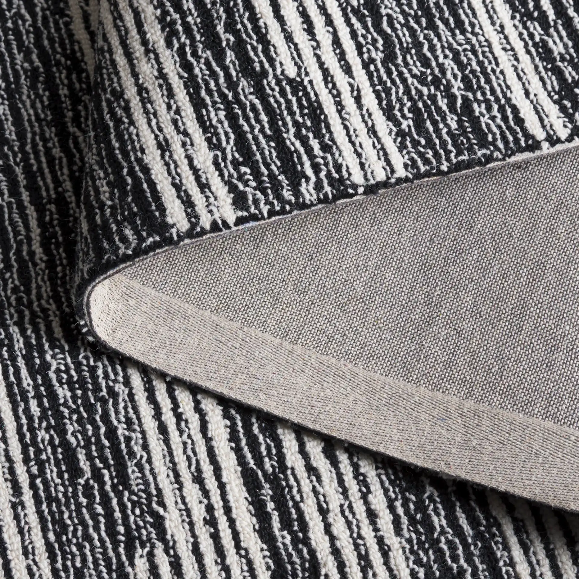 Ebony Broken Stripe Hand-Tufted Wool Rug in Black / Ivory in a styled room
