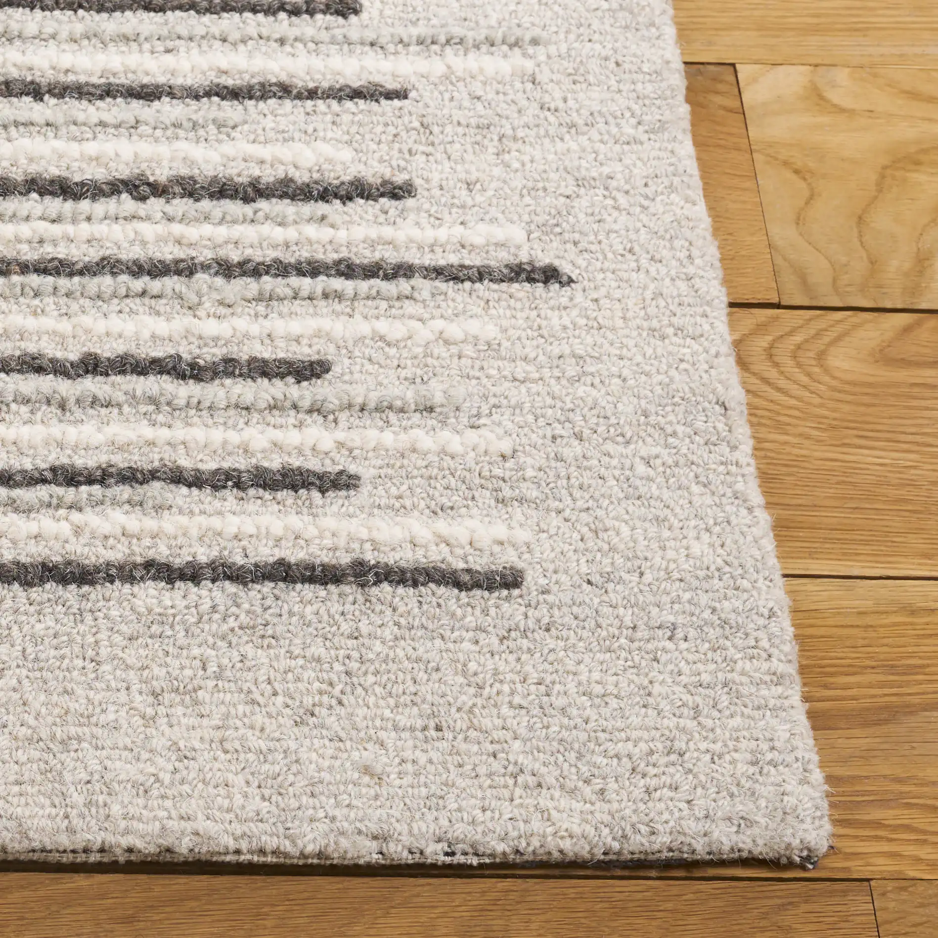 Ebony Dashed Stripe Hand-Tufted Wool Rug in Gray / Black in a styled room