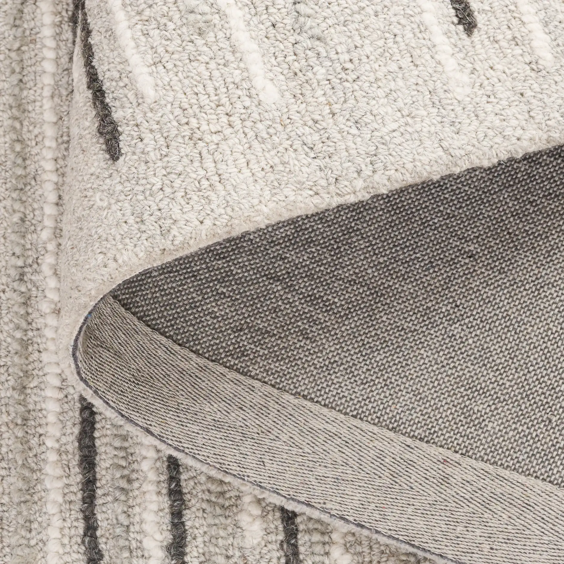 Ebony Dashed Stripe Hand-Tufted Wool Rug in Gray / Black in a styled room