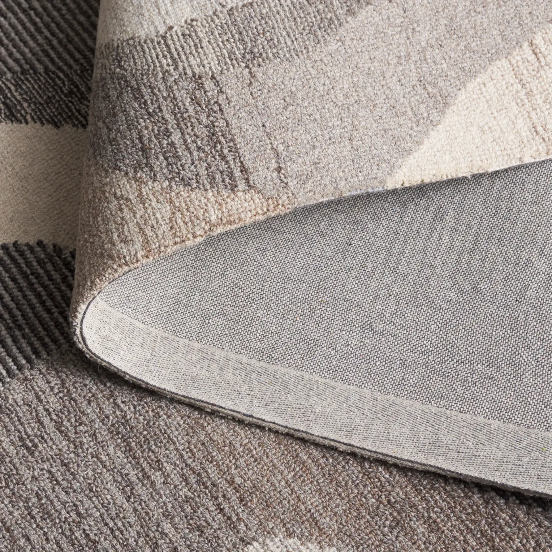 Ebony Abstract Wave Hand-Tufted Wool Rug in Gray / Ivory in a styled room