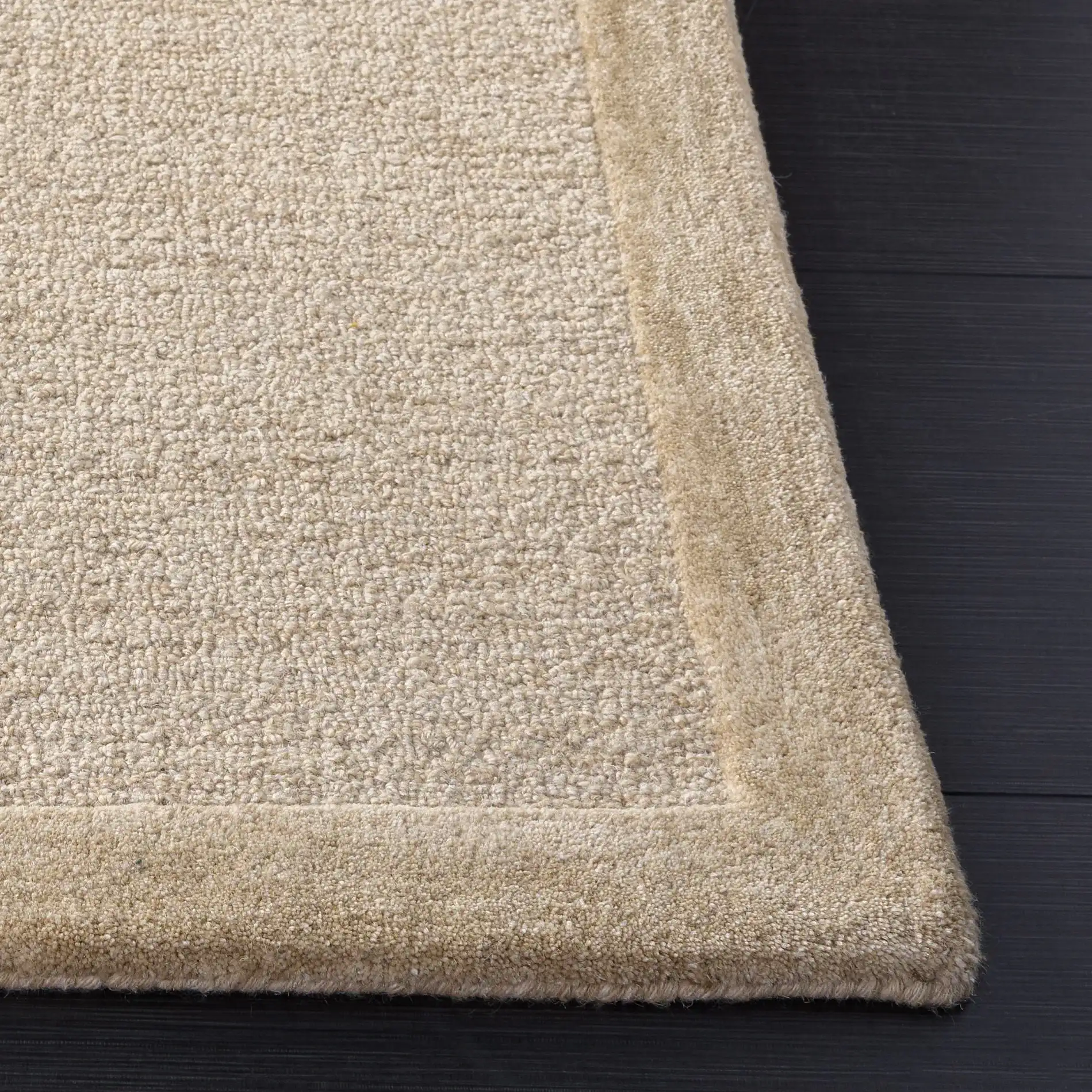 Ebony Solid Border Hand-Tufted Wool Rug in Beige in a styled room