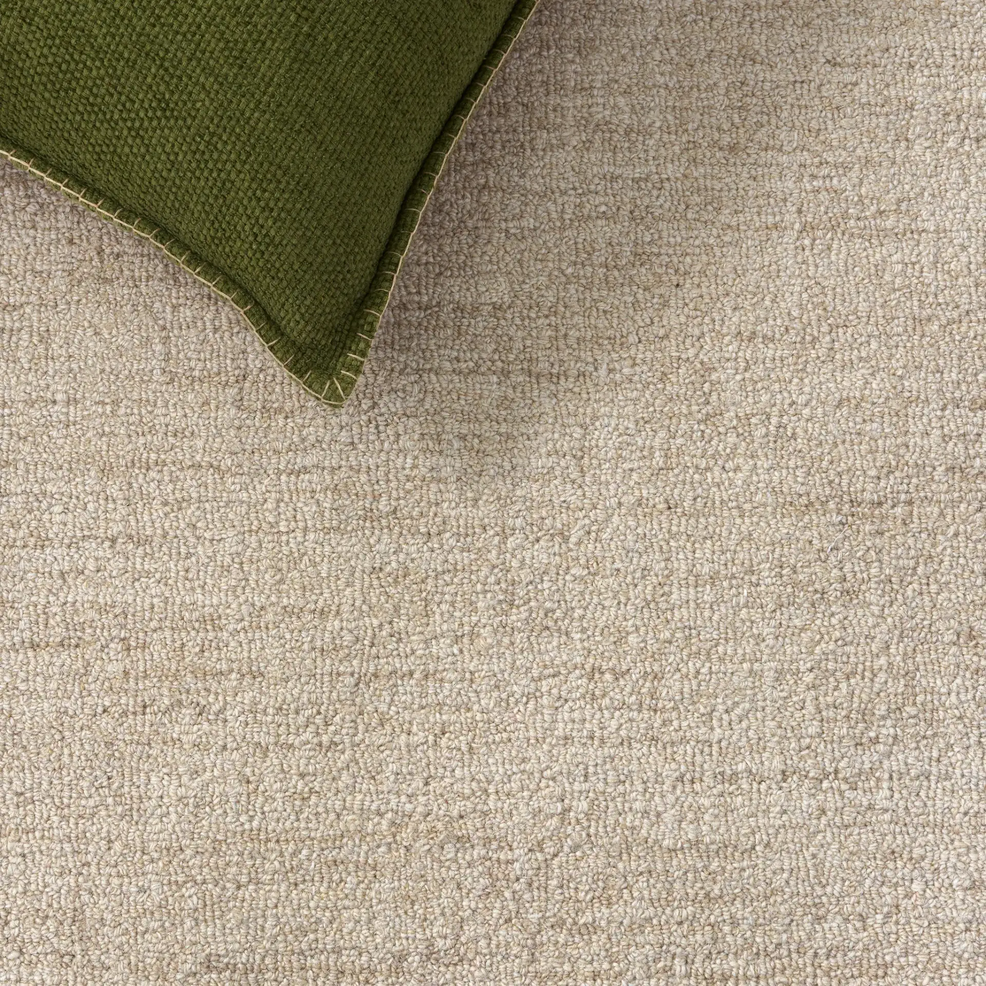 Ebony Solid Border Hand-Tufted Wool Rug in Beige in a styled room