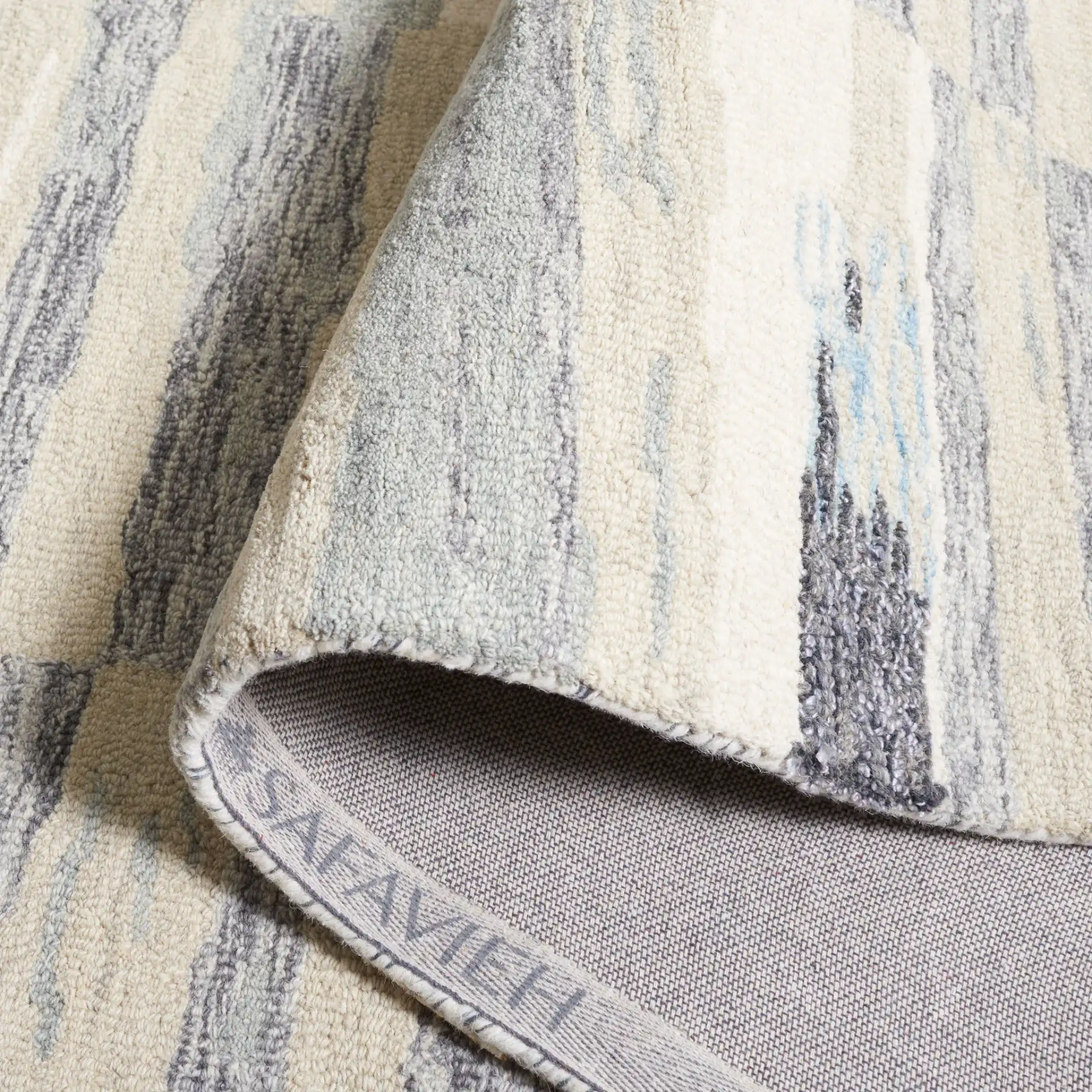 Ebony Abstract Drip Hand-Tufted Wool Rug in Ivory / Gray in a styled room
