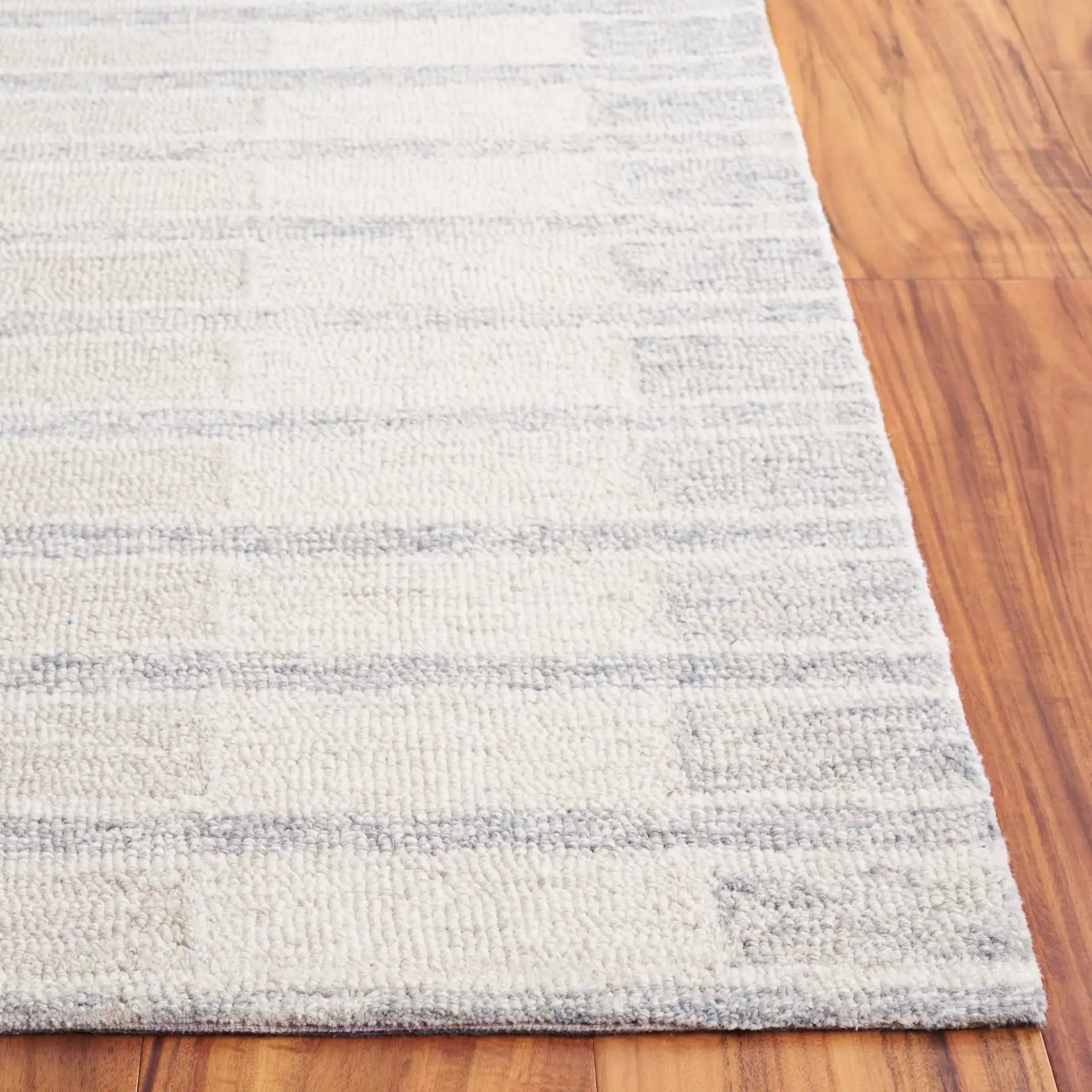 Ebony Horizontal Stripe Hand-Tufted Wool Rug in Beige / Gray in a styled room