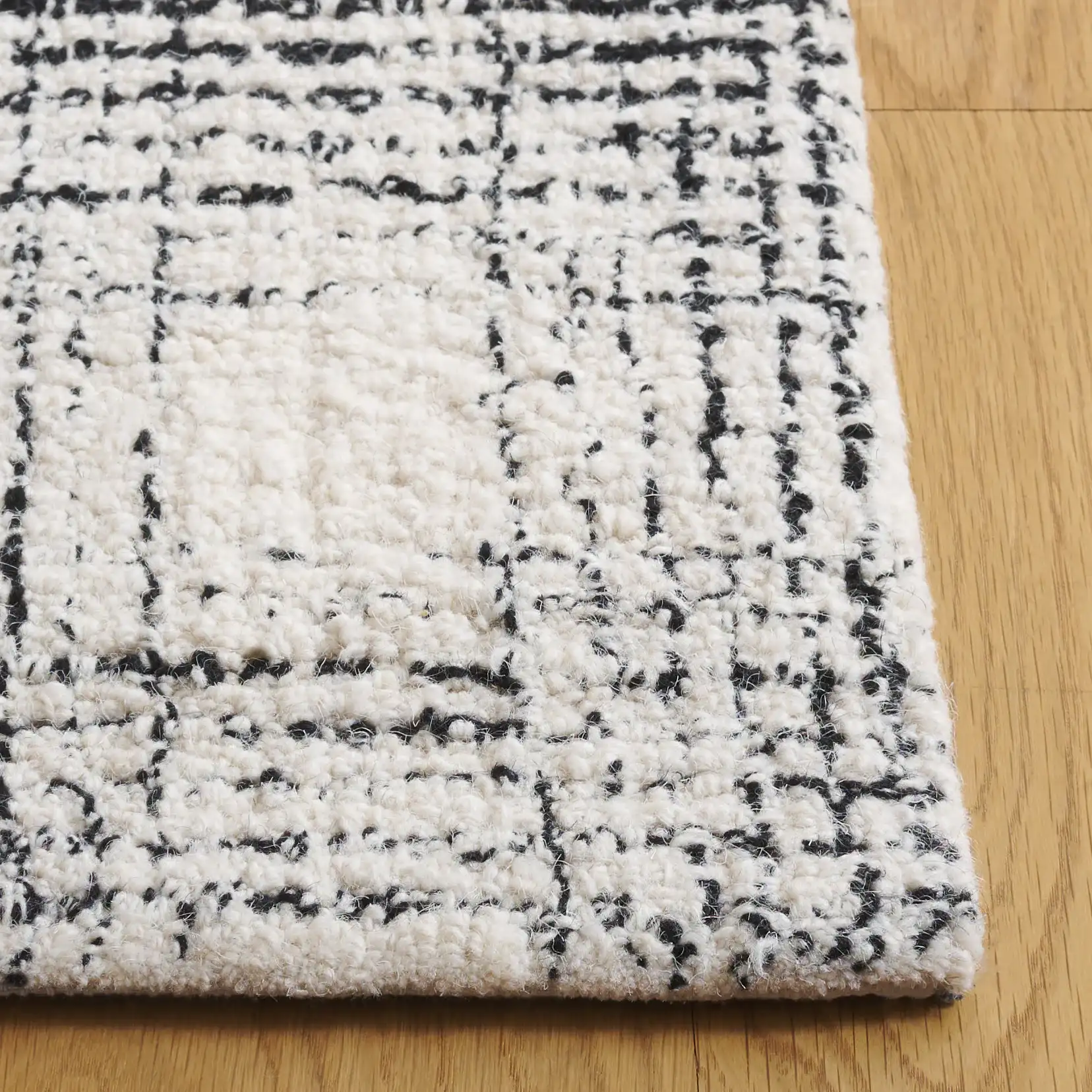 Ebony Gingham Plaid Hand-Tufted Wool Rug in Ivory / Black in a styled room