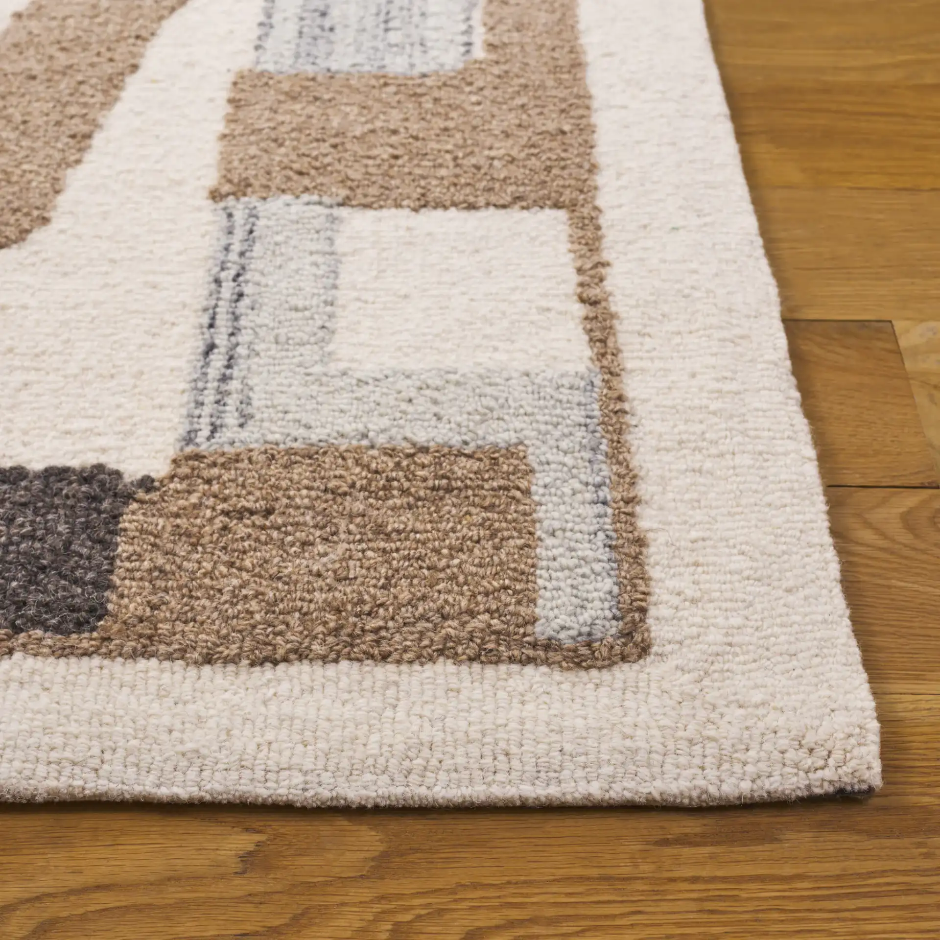 Ebony Abstract Patchwork Collage Hand-Tufted Wool Rug in Ivory / Brown in a styled room